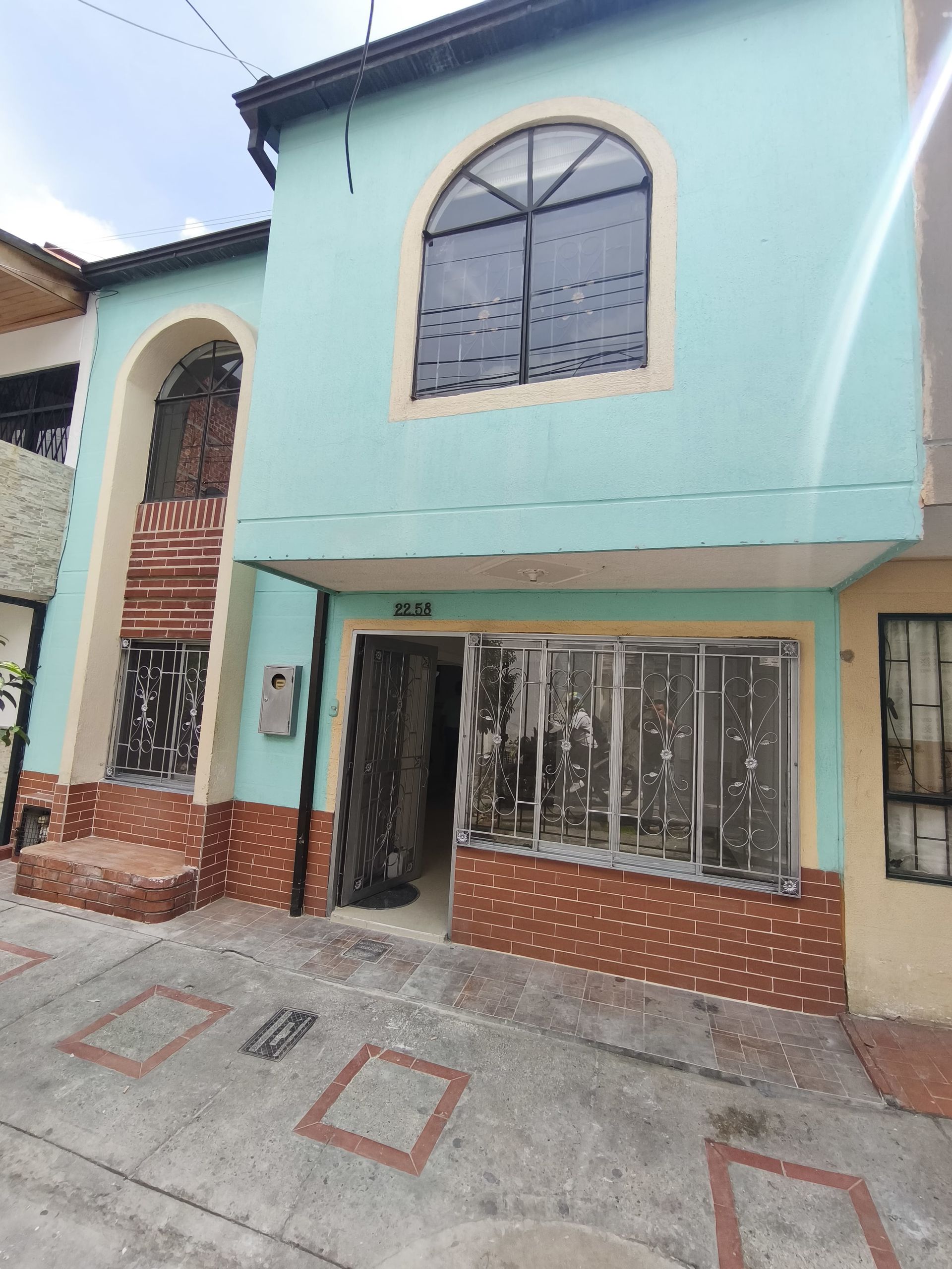 Una casa verde con muchas ventanas y escaleras.
