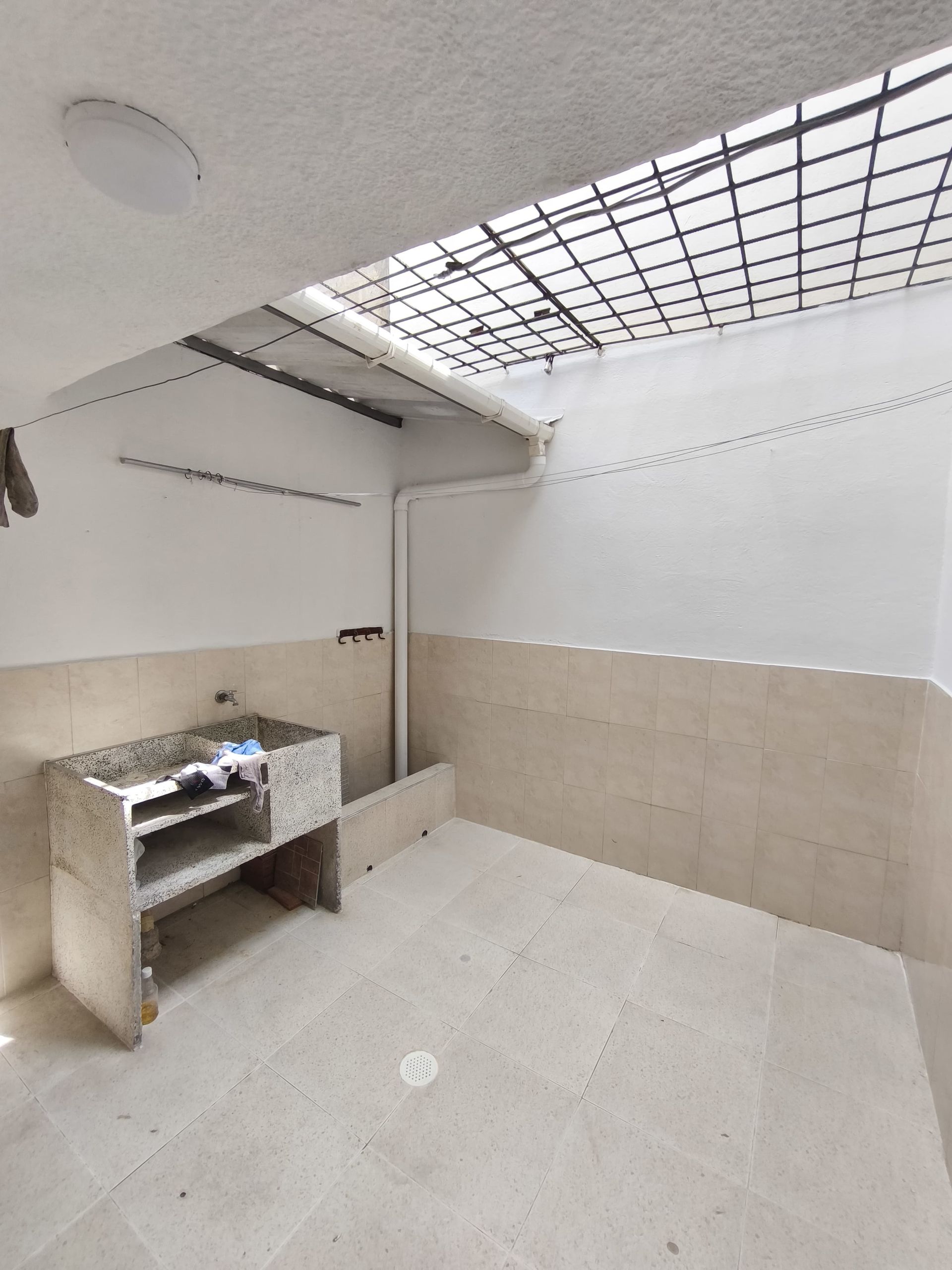 Una habitación vacía con un lavabo y una ventana.