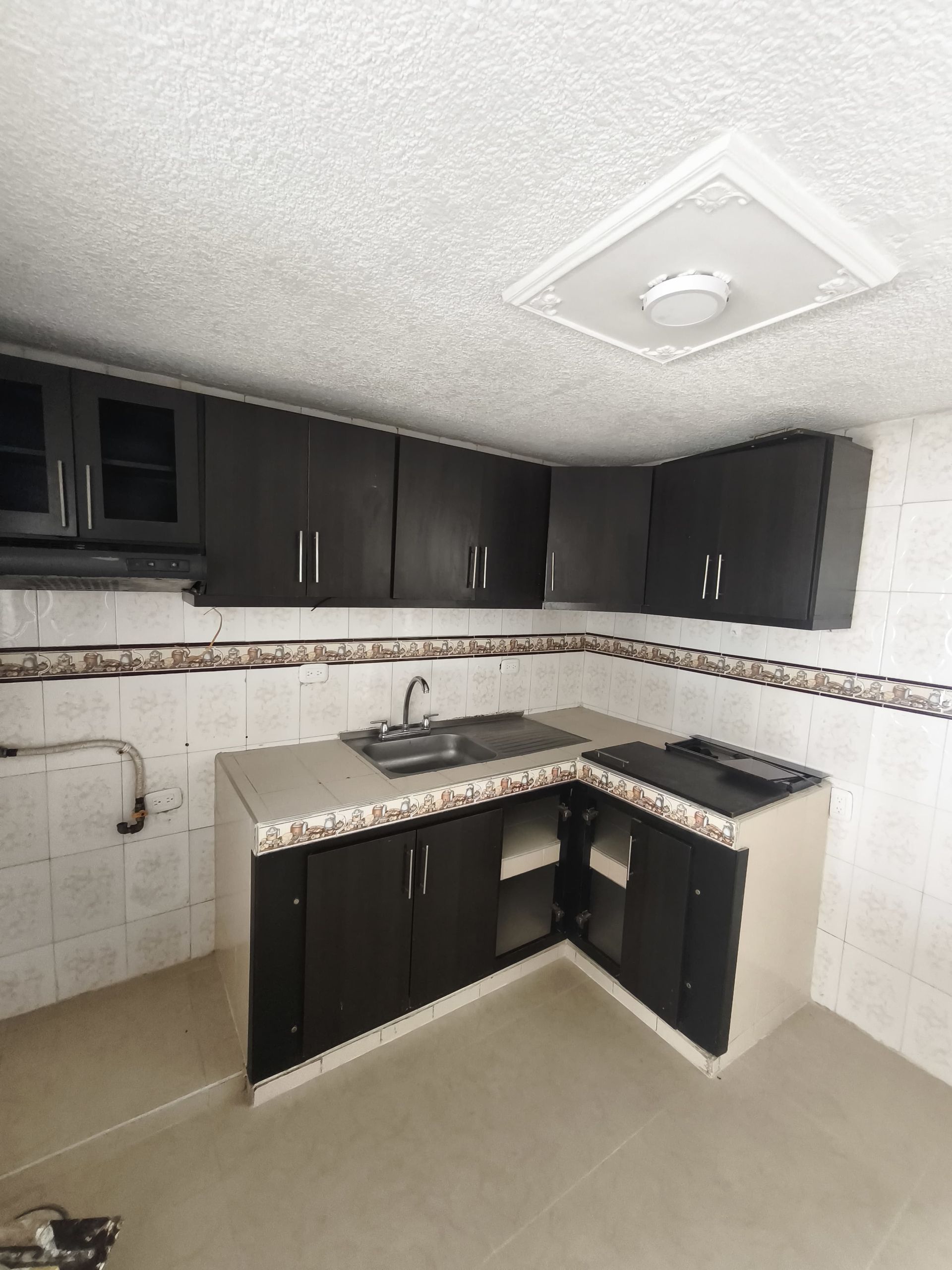 Una cocina con gabinetes negros y un fregadero.