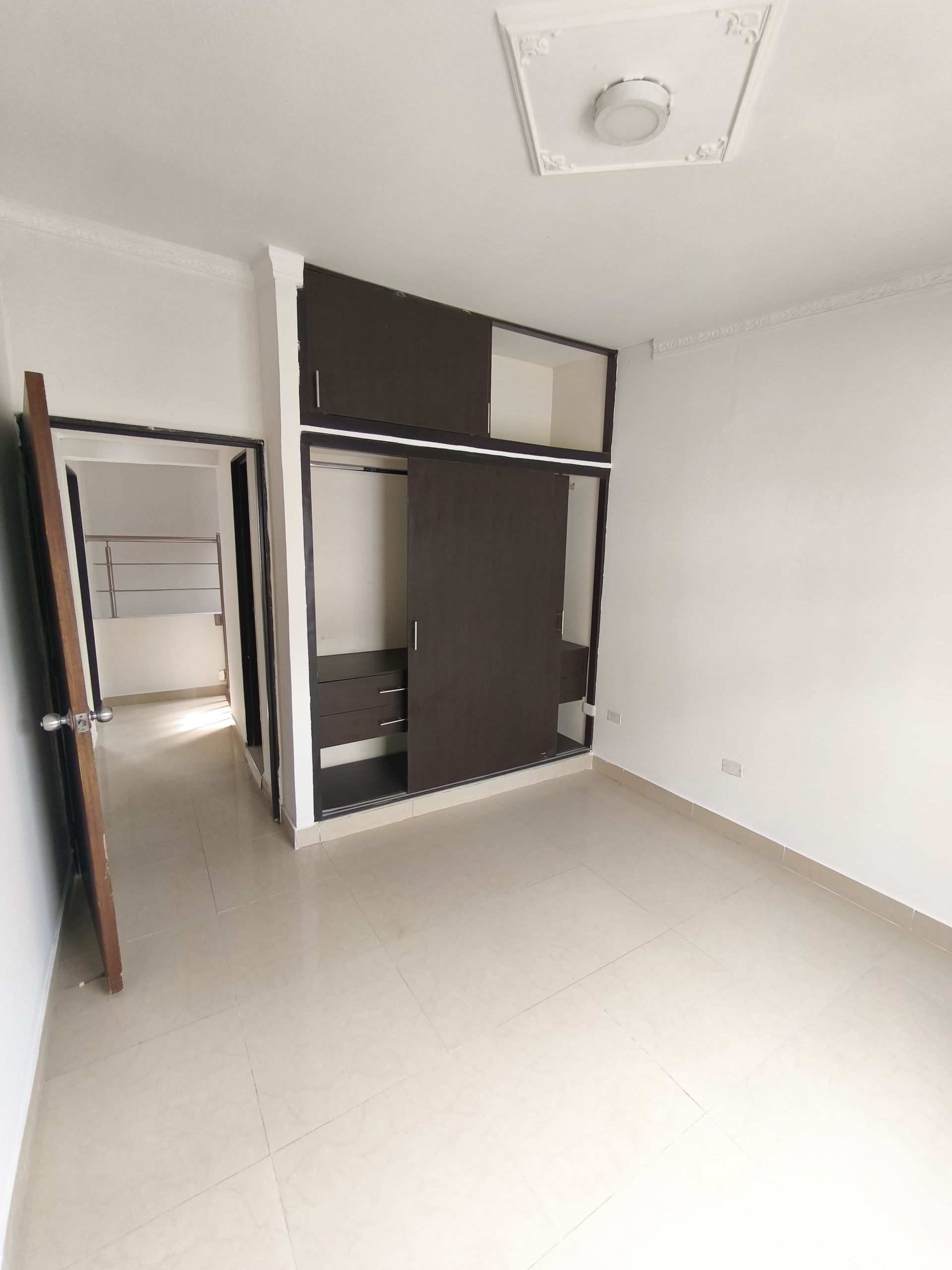 Una gran habitación vacía con un armario y una puerta.