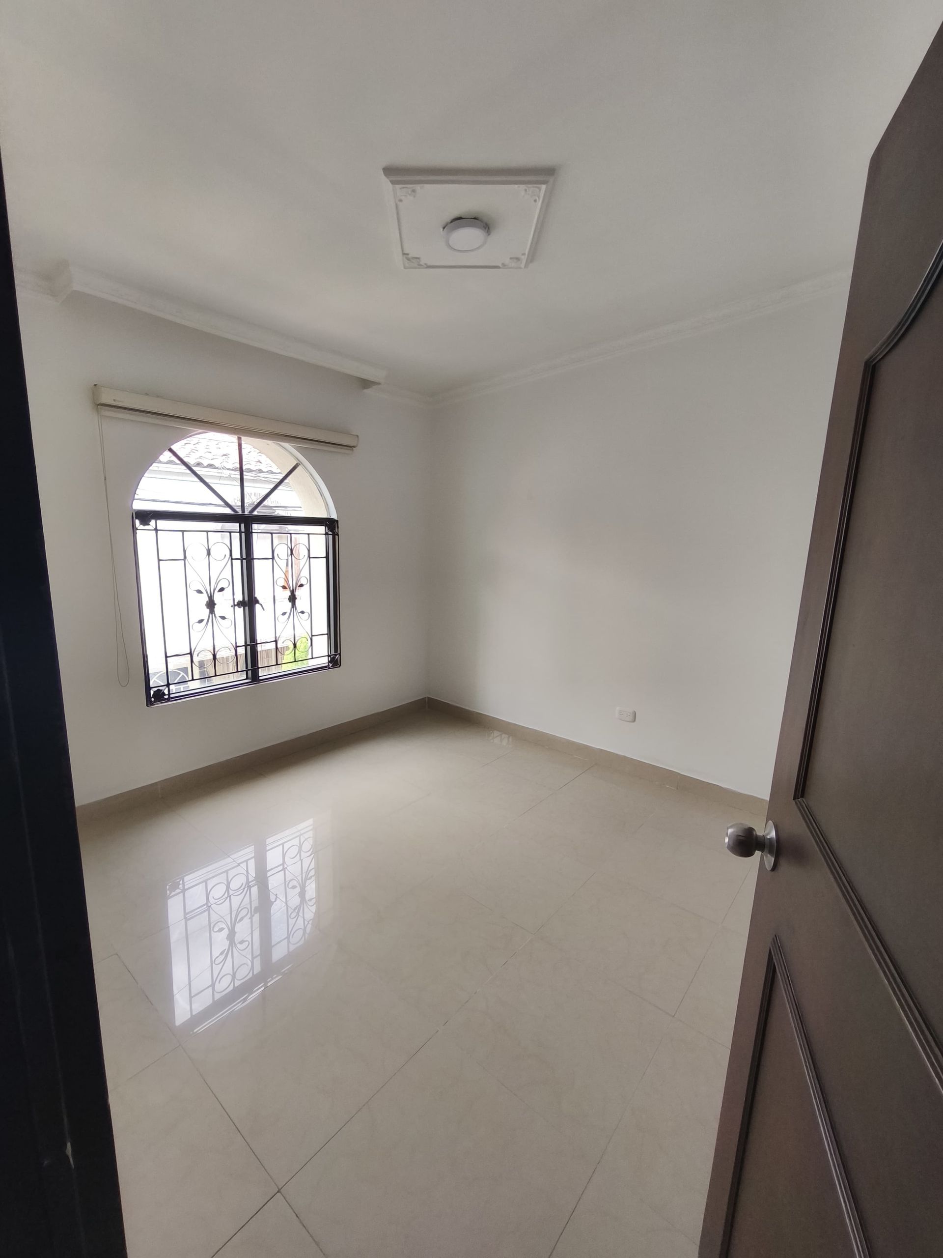 Una habitación vacía con una ventana y una puerta.