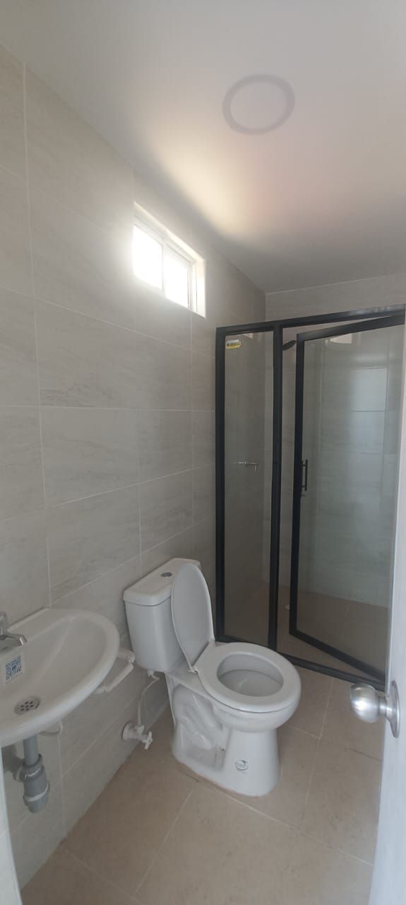 Un baño con inodoro, lavabo y ducha.