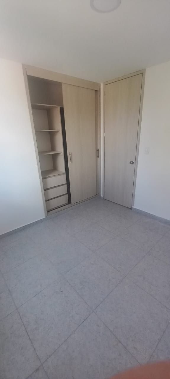 Una habitación vacía con una escalera que conduce a un armario.