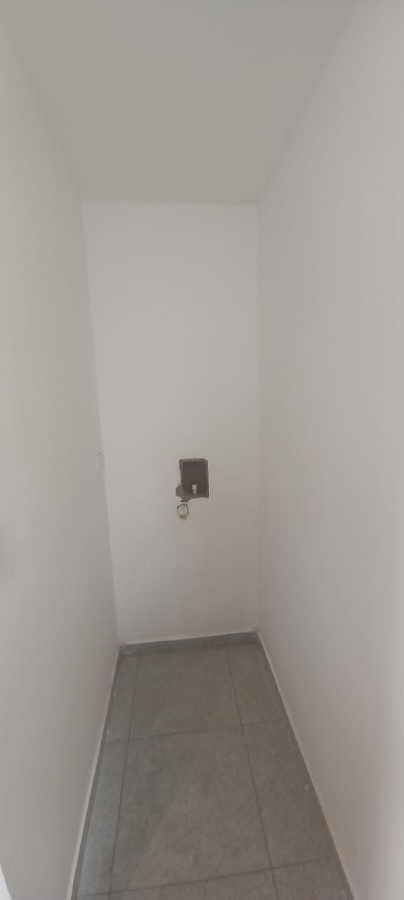 Una habitación vacía con suelo de baldosas y paredes blancas.