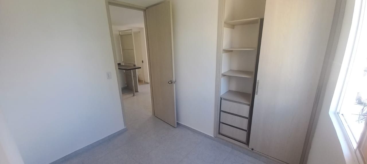 Una pequeña habitación con un armario y una ventana.