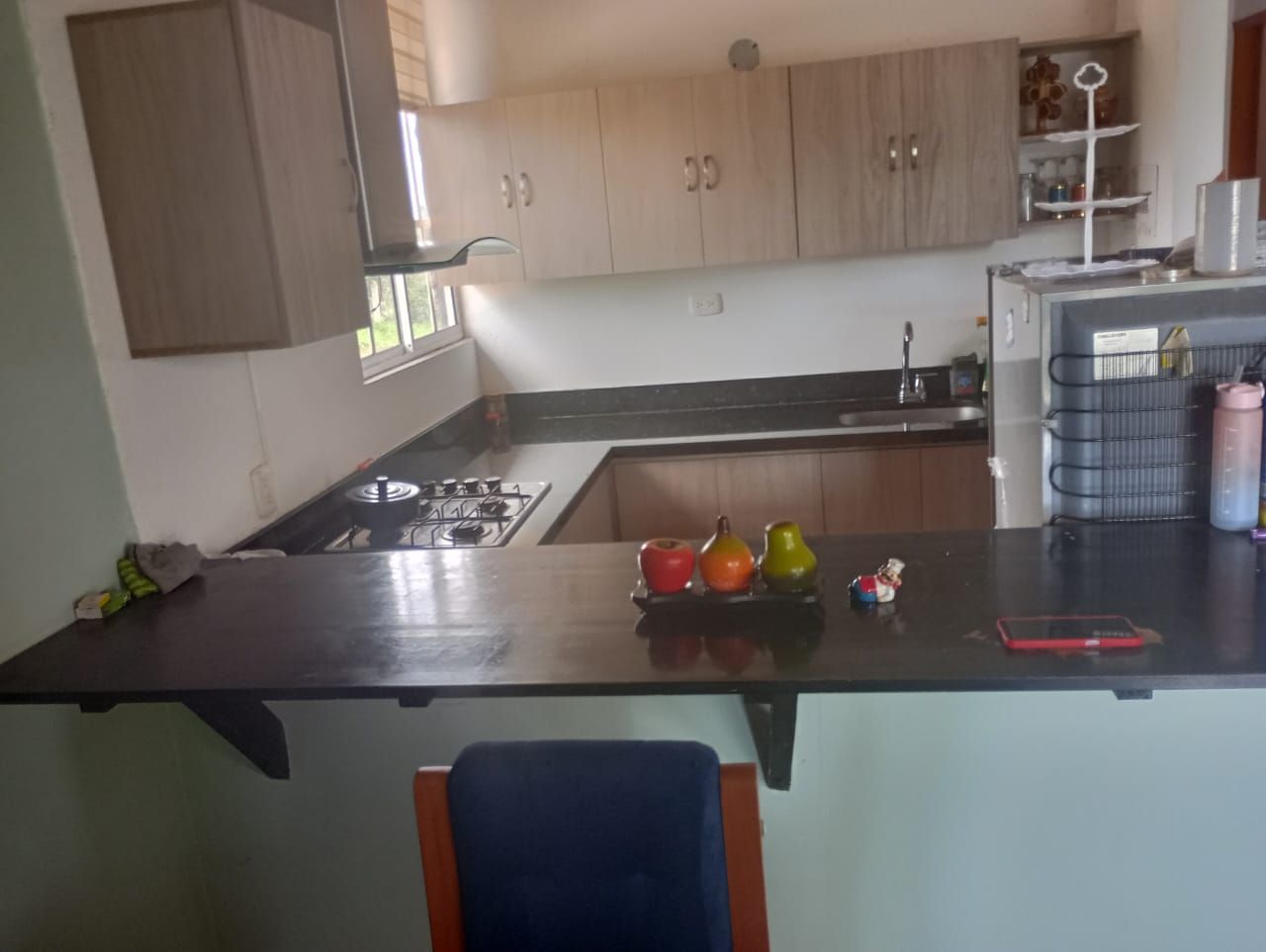 Una cocina con una encimera negra y fruta encima.