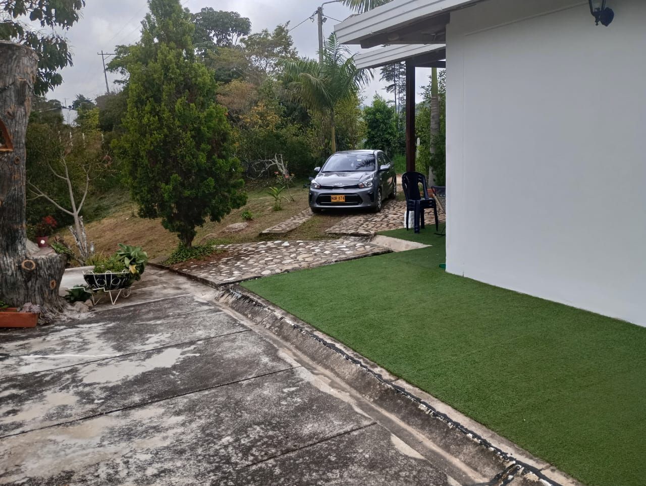 Un coche está aparcado delante de un edificio blanco.