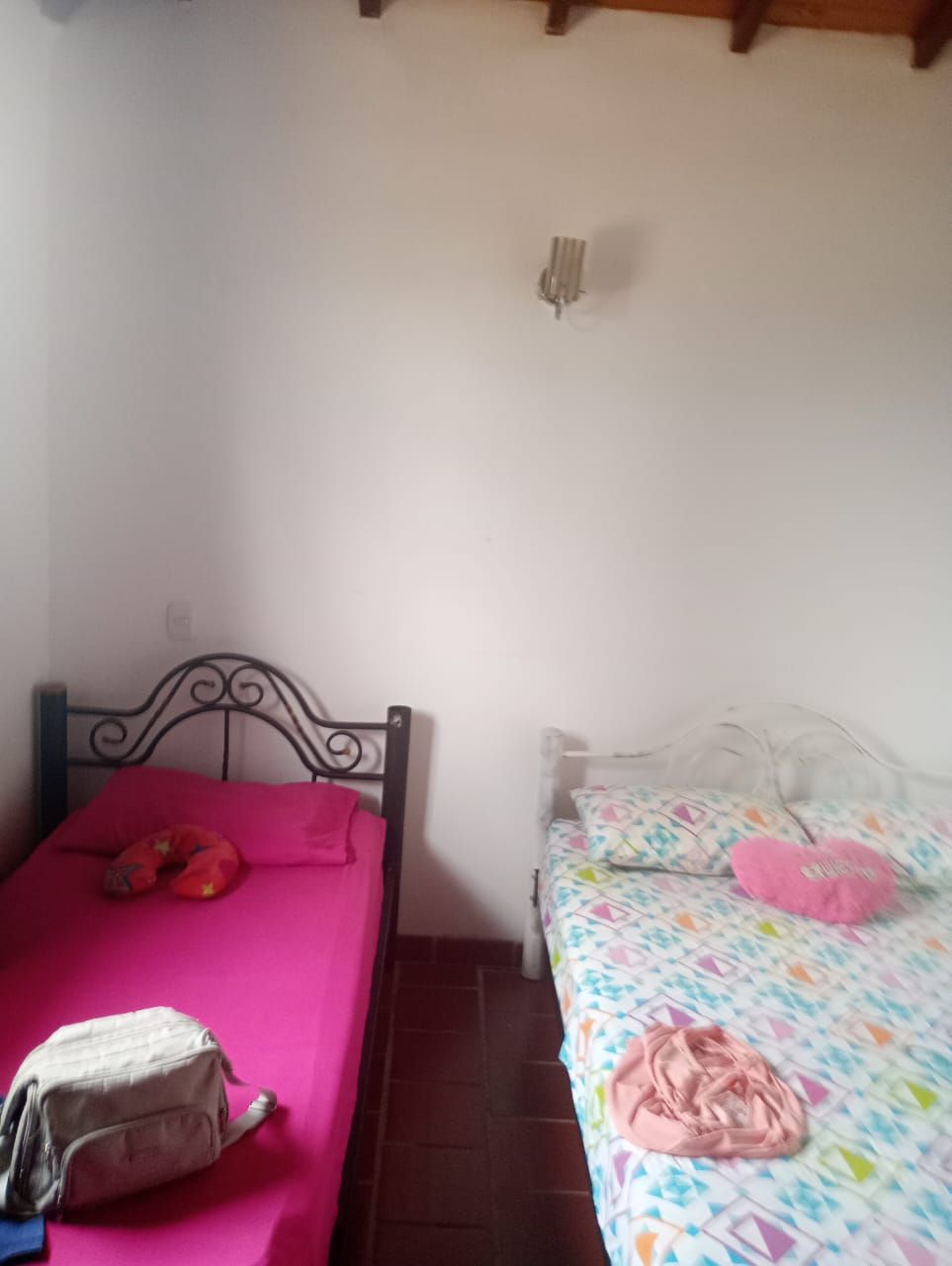 Un dormitorio con dos camas y una bolsa en el suelo.