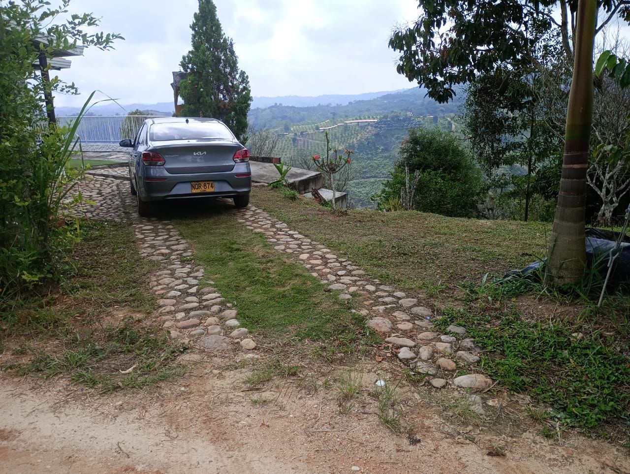 Un coche está estacionado al costado de un camino de tierra.