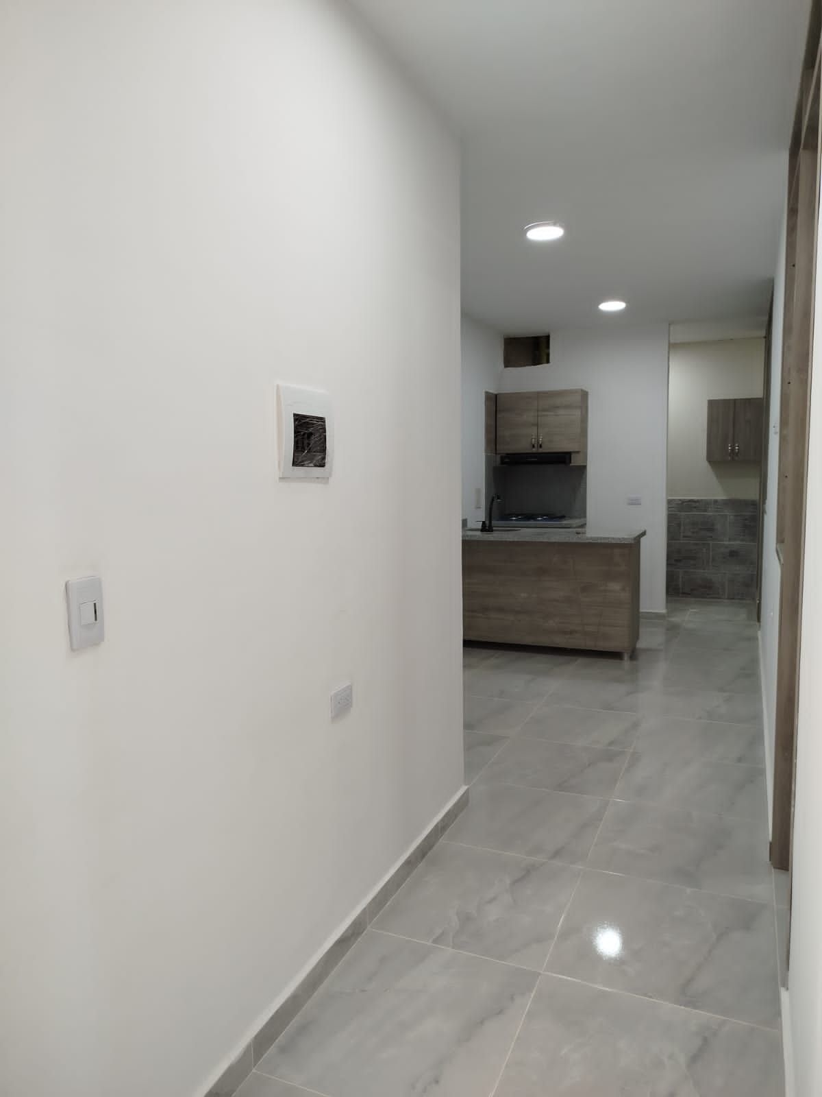 Un pasillo que conduce a una cocina en una casa.