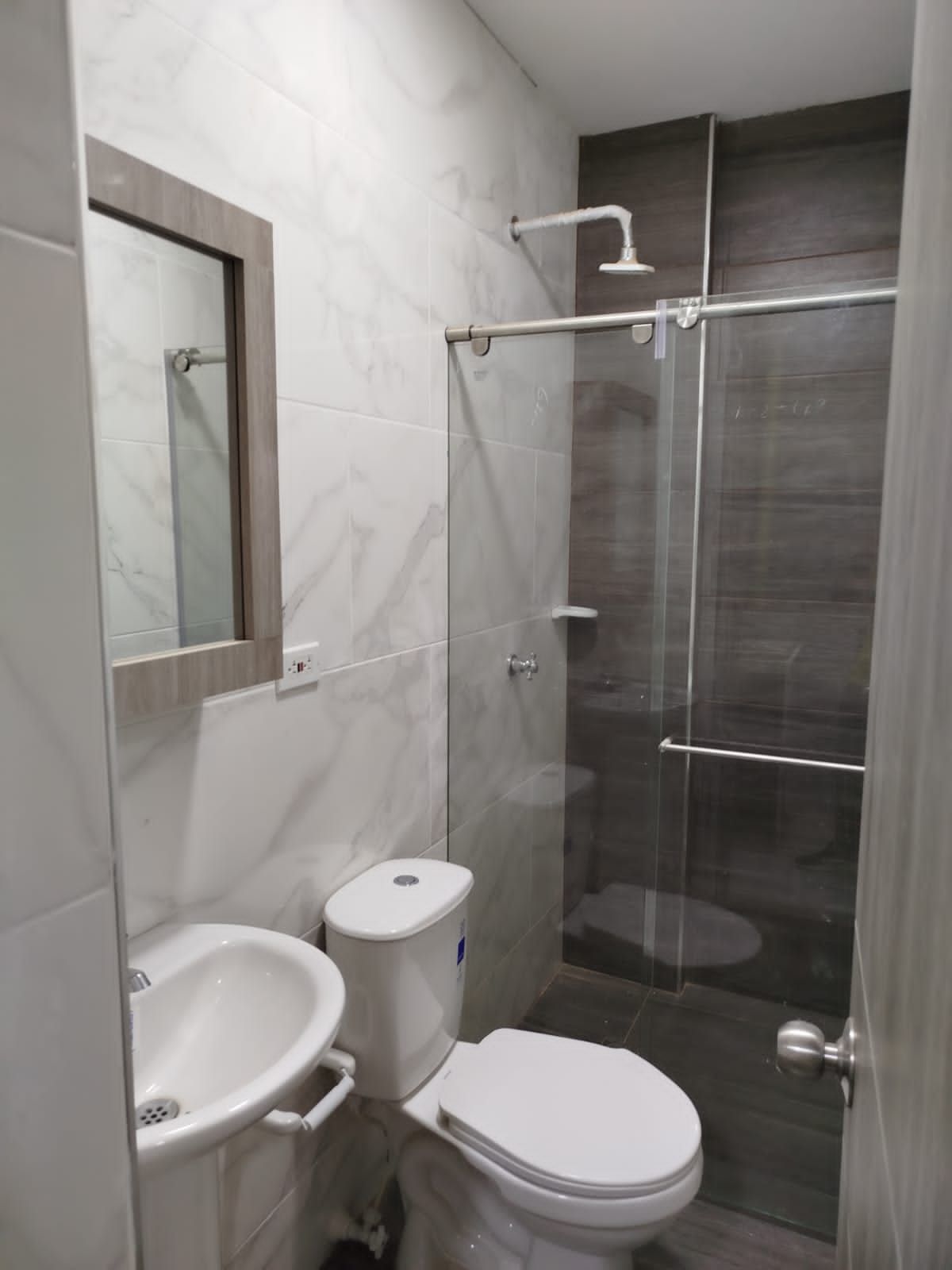 Un baño con inodoro, lavabo y ducha.