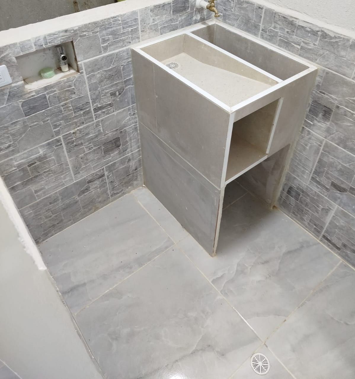 Un baño con un lavabo y un estante debajo.