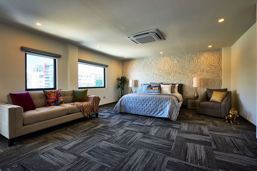Studio interior at Ola Boutique Hotel with a bed, a sofa, an armchair and two windows