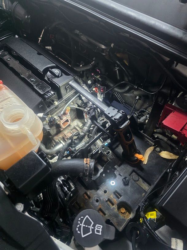 A Close Up Of A Car Engine With A Bottle Of Oil In It — Nuron Inspection & Service Centre In Broadmeadow, NSW