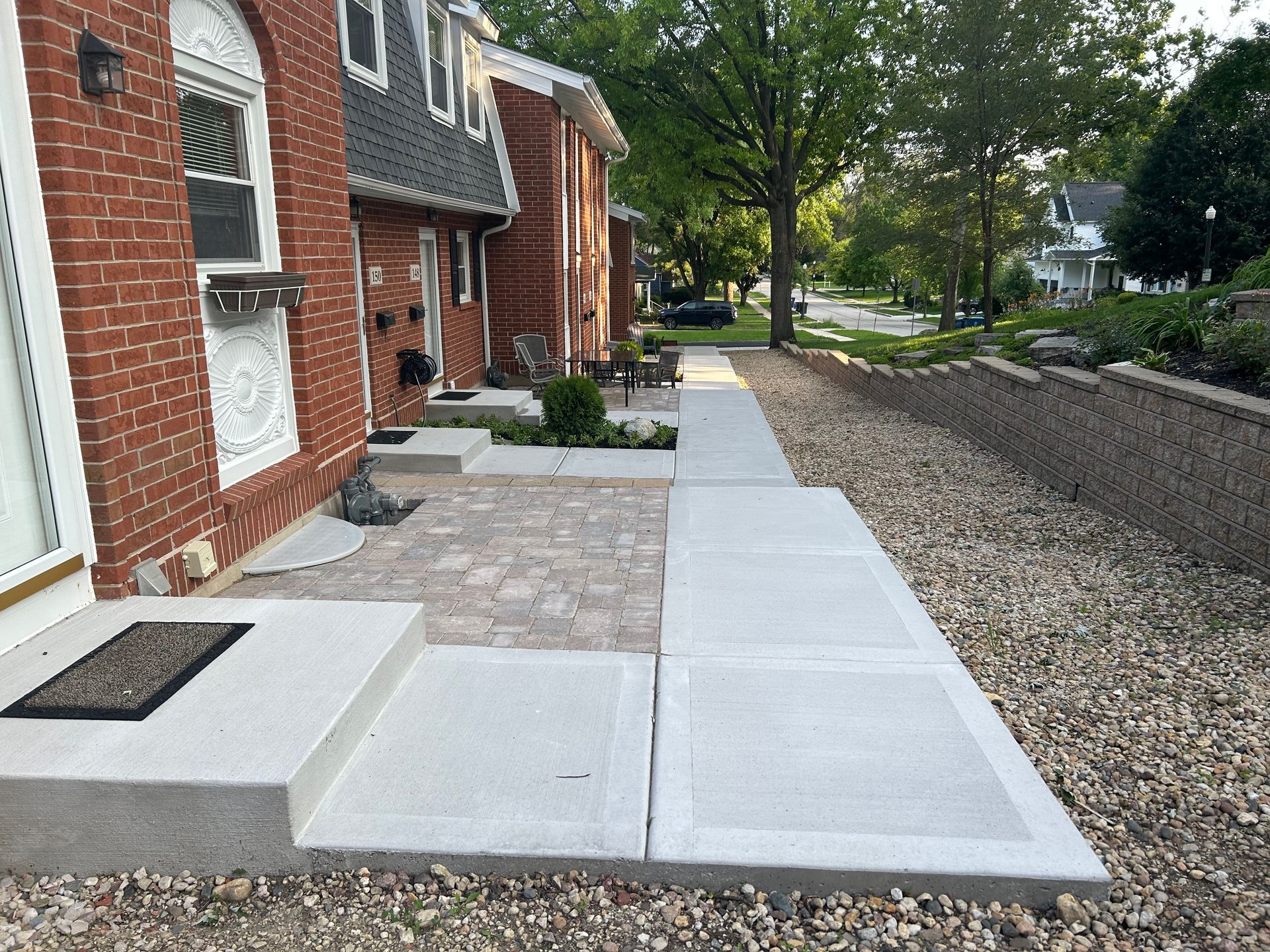 a brick house with a concrete walkway in front of it