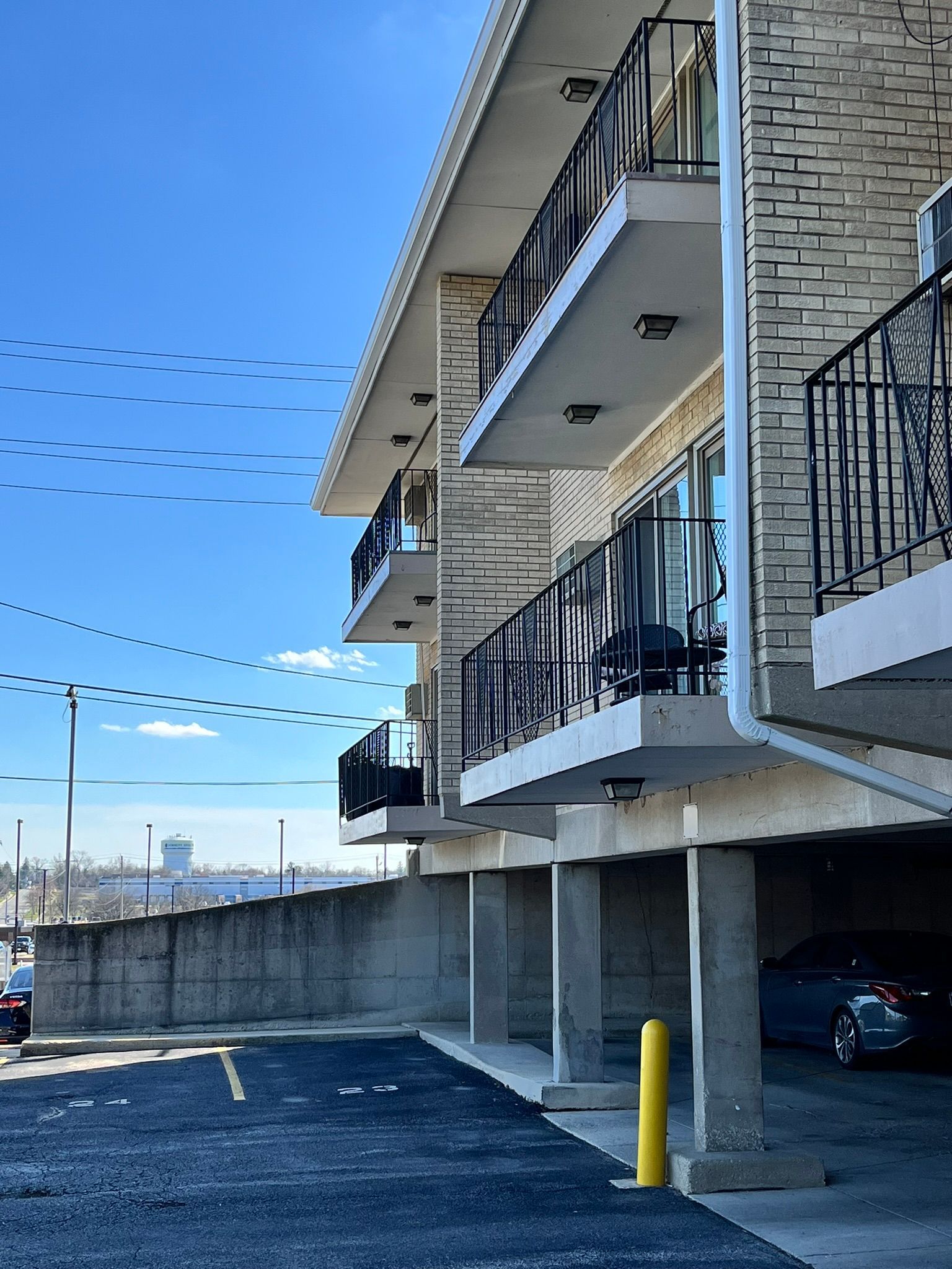 a building with balconies and a car parked underneath it