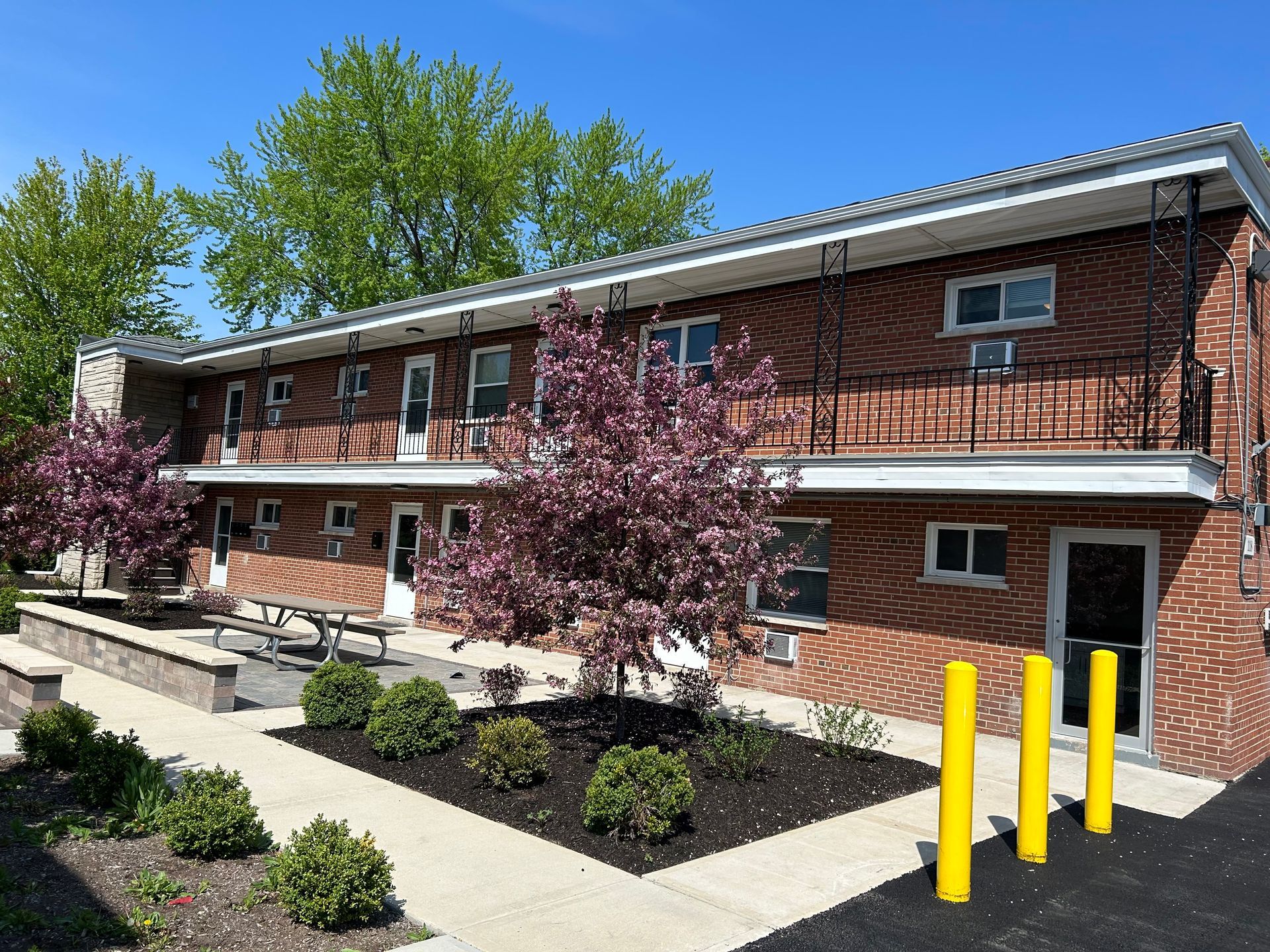 a brick apartment building with a picnic table in front of it