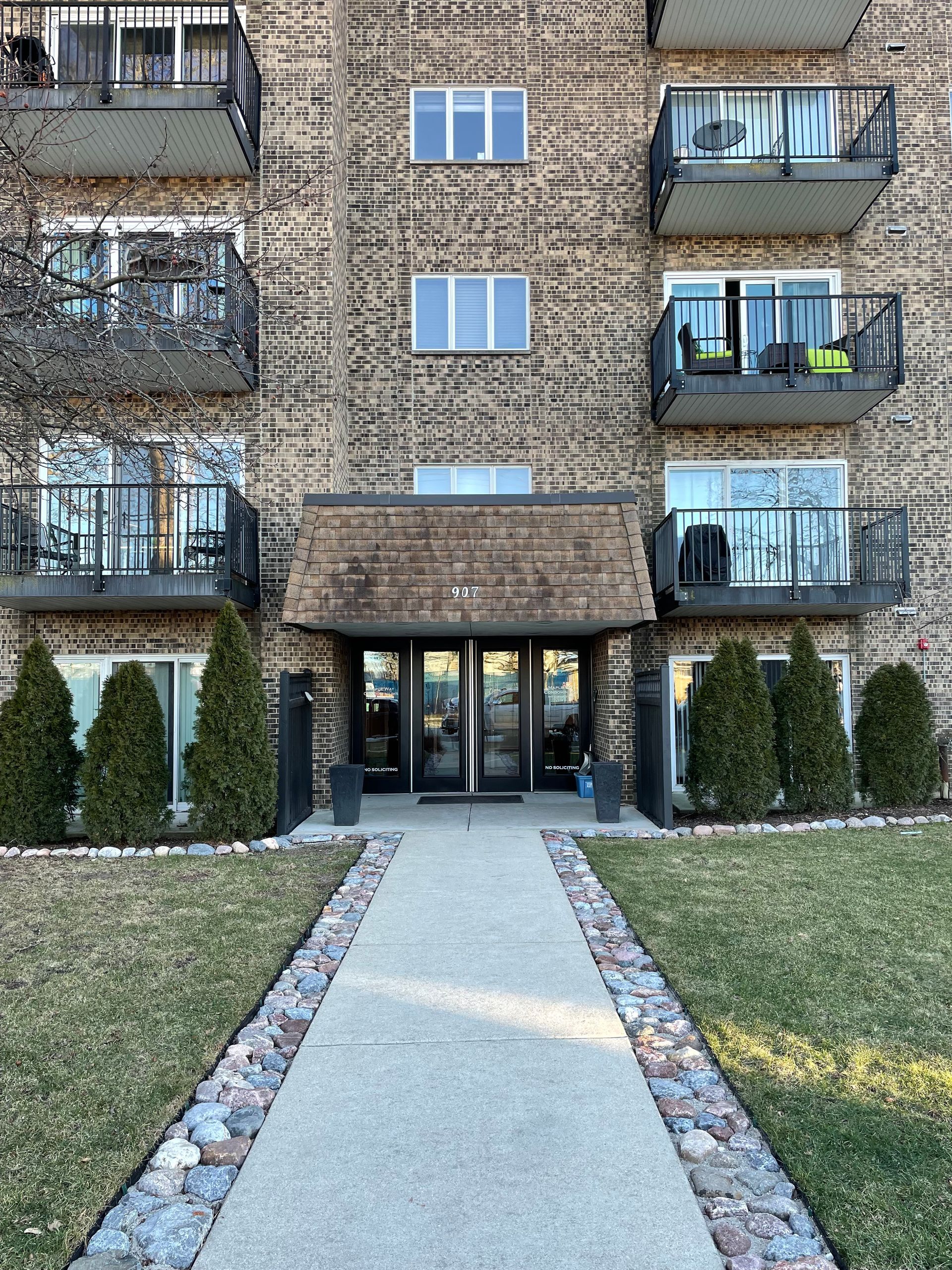 a brick apartment building with a walkway leading to the entrance
