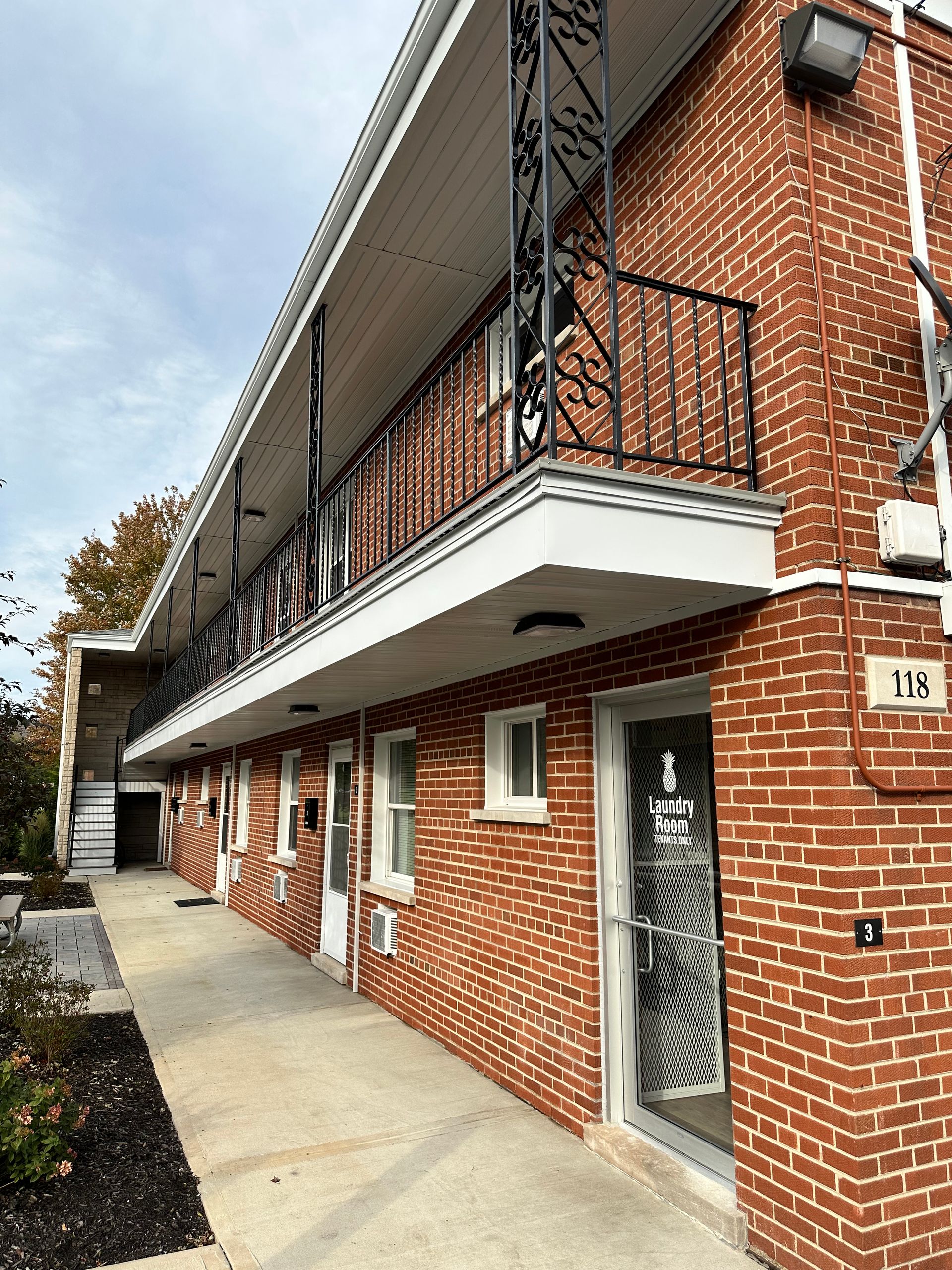 a brick apartment building with a balcony and stairs