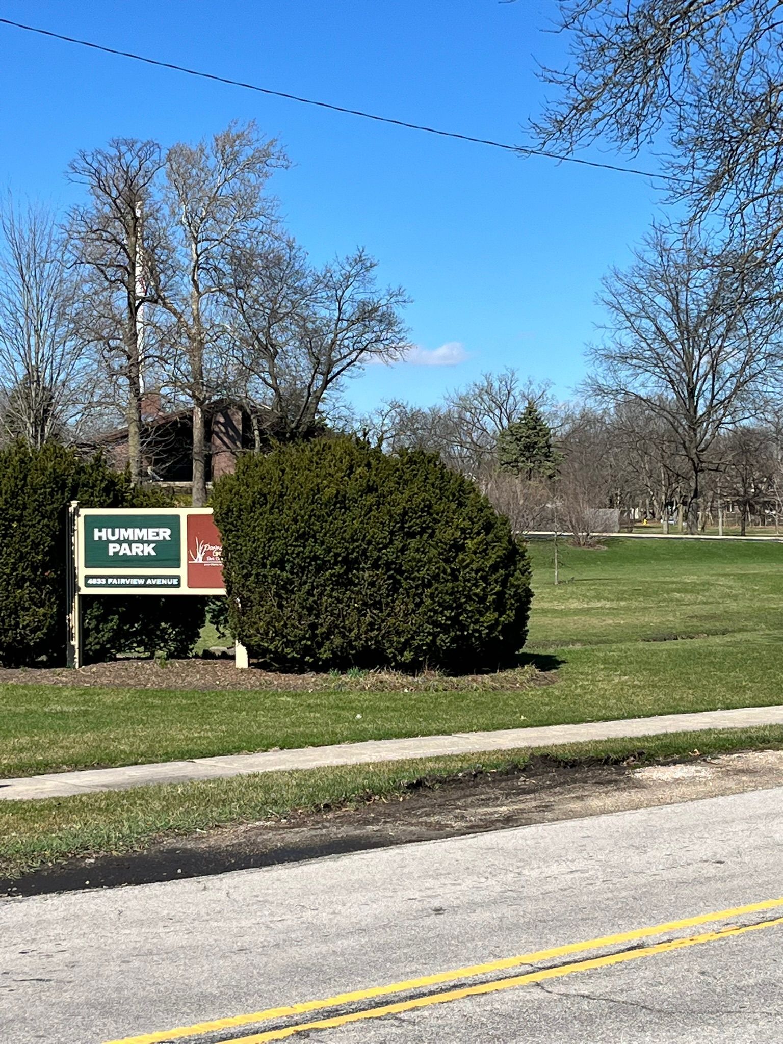 a sign for a park is sitting on the side of the road .