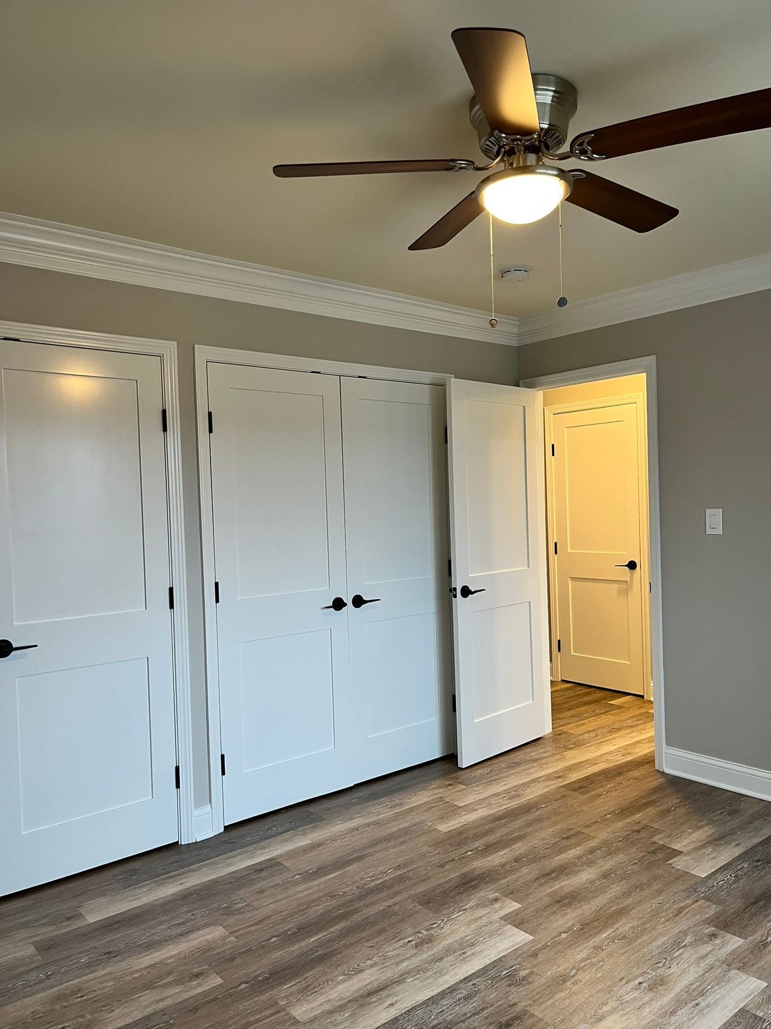 There is a ceiling fan in the corner of the room.
