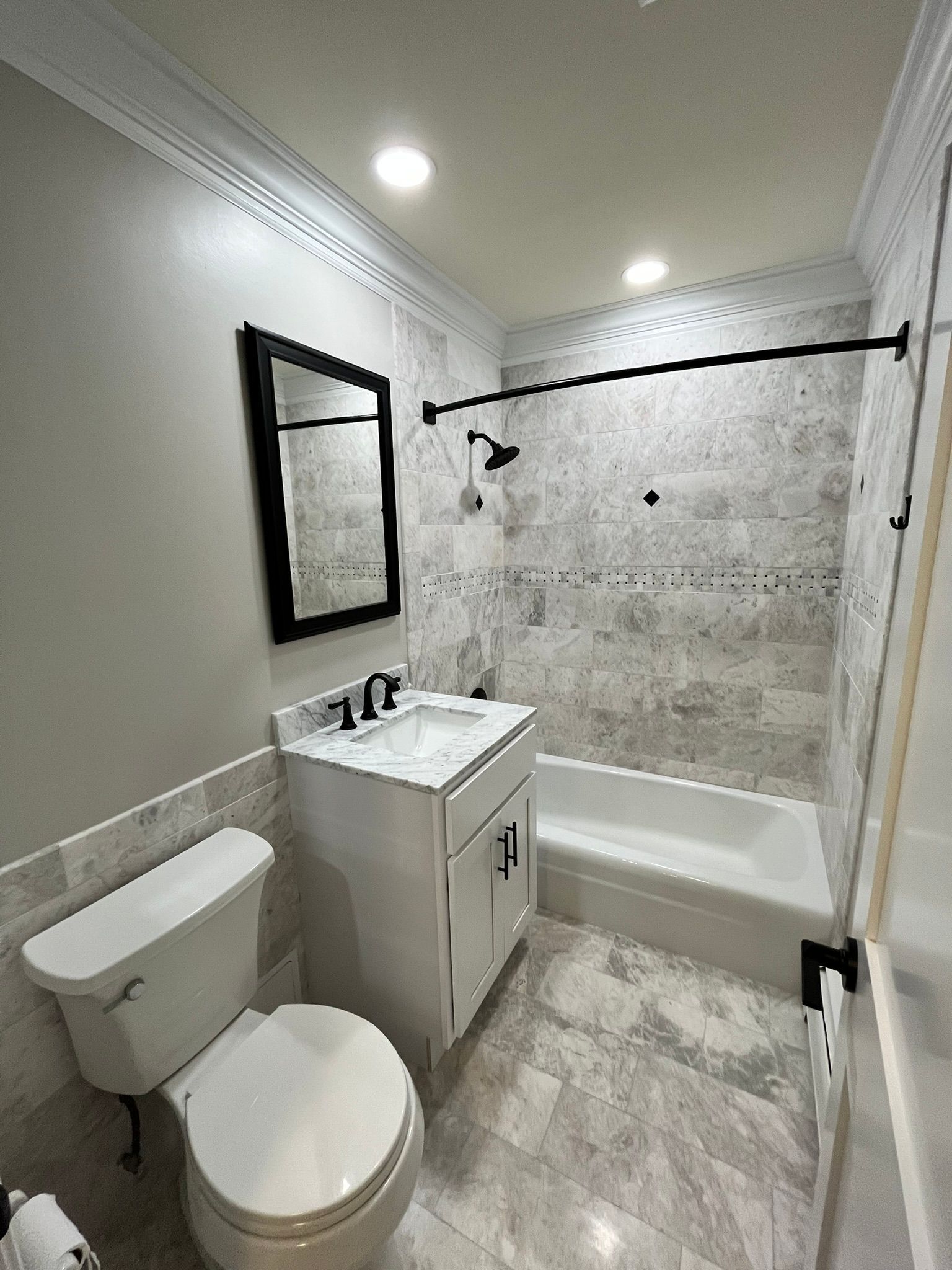 A bathroom with a toilet , sink , and bathtub.