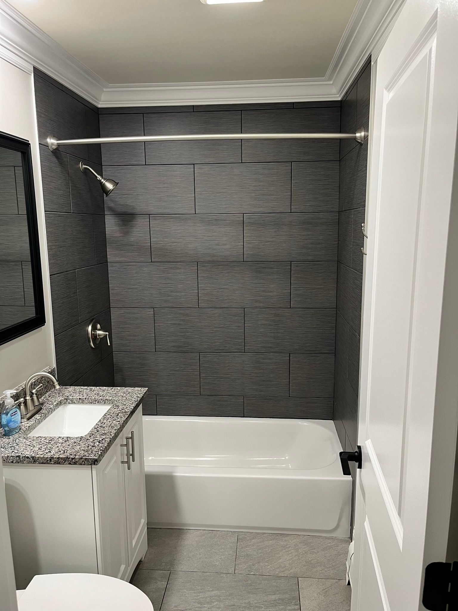 A bathroom with a bathtub , sink , toilet and mirror.