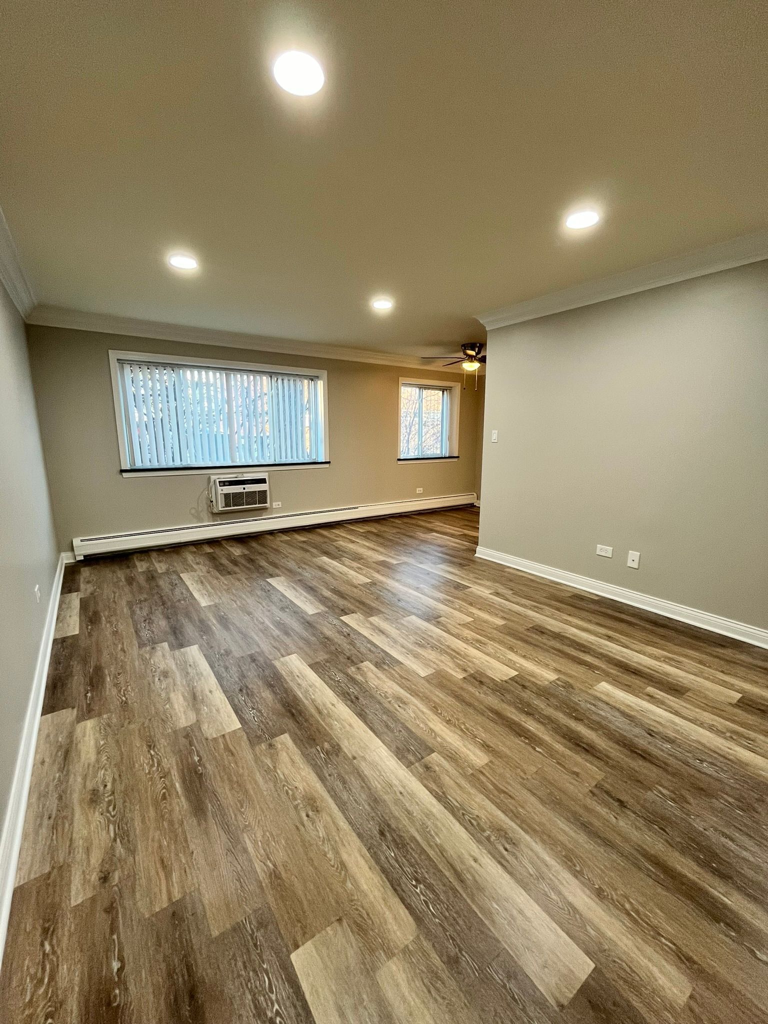A living room with hardwood floors and a window.