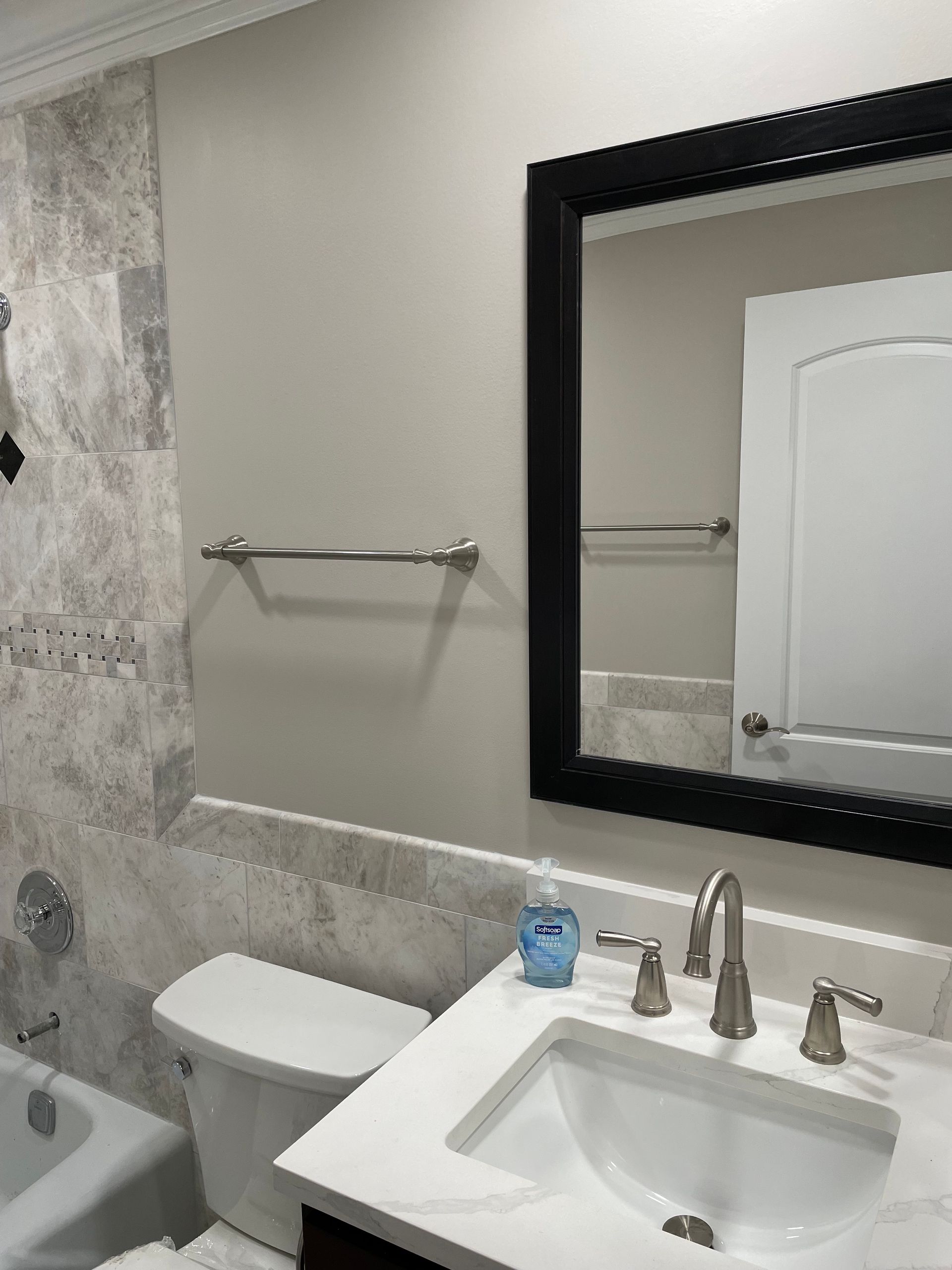 a bathroom with a sink , toilet , tub and mirror .