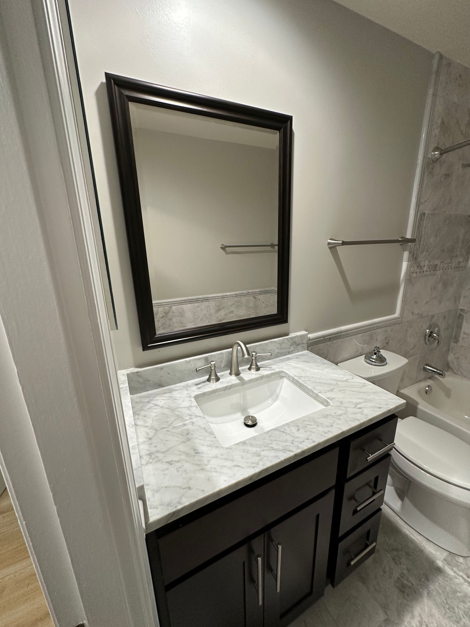 a bathroom with a sink , toilet , bathtub and mirror .