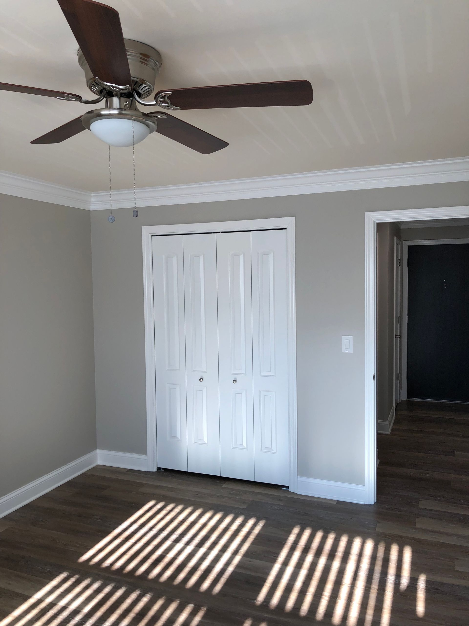 an empty room with a ceiling fan and a closet
