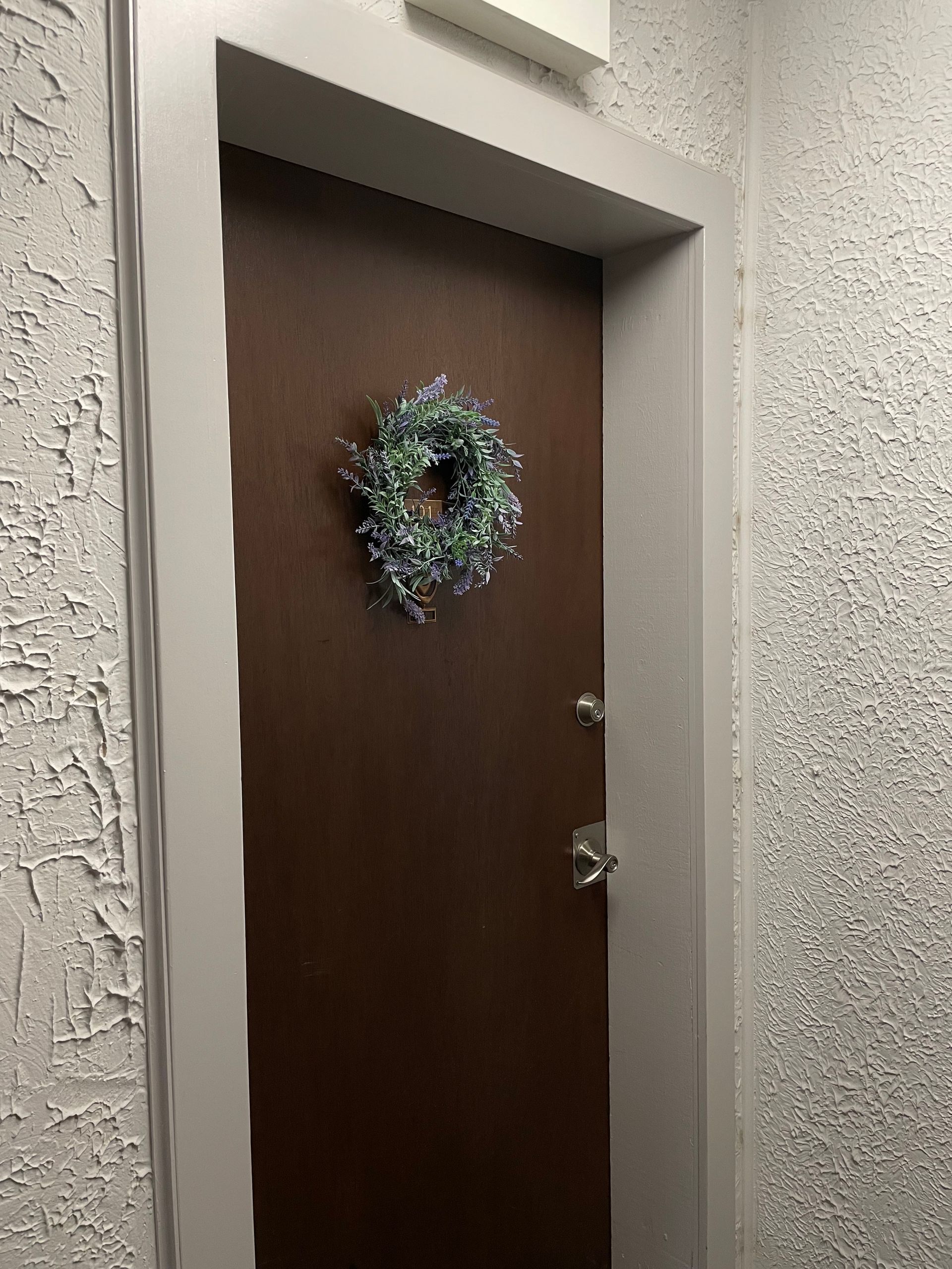 a door with a wreath hanging on it in a hallway .