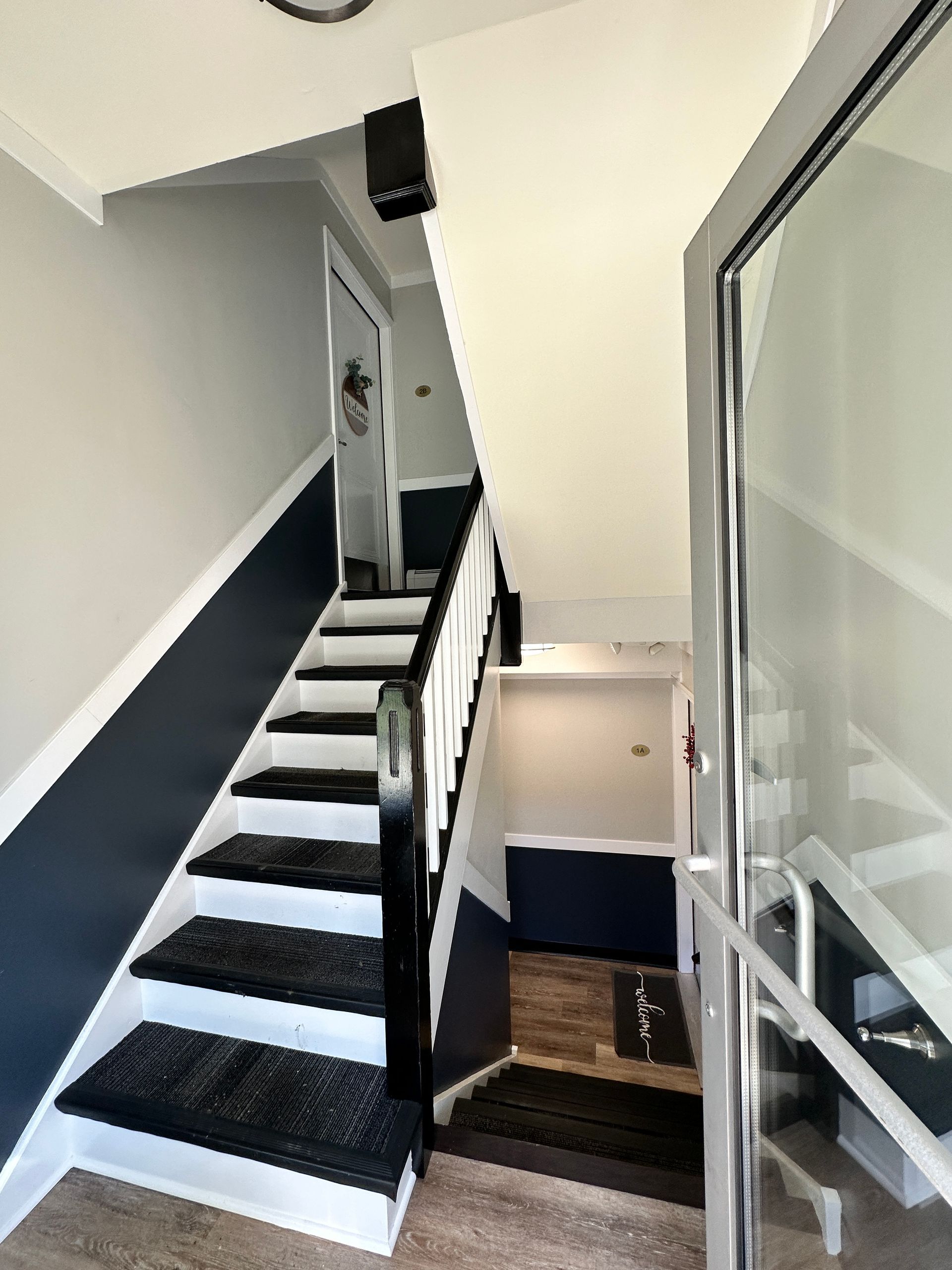 a black and white staircase in a house with a glass door