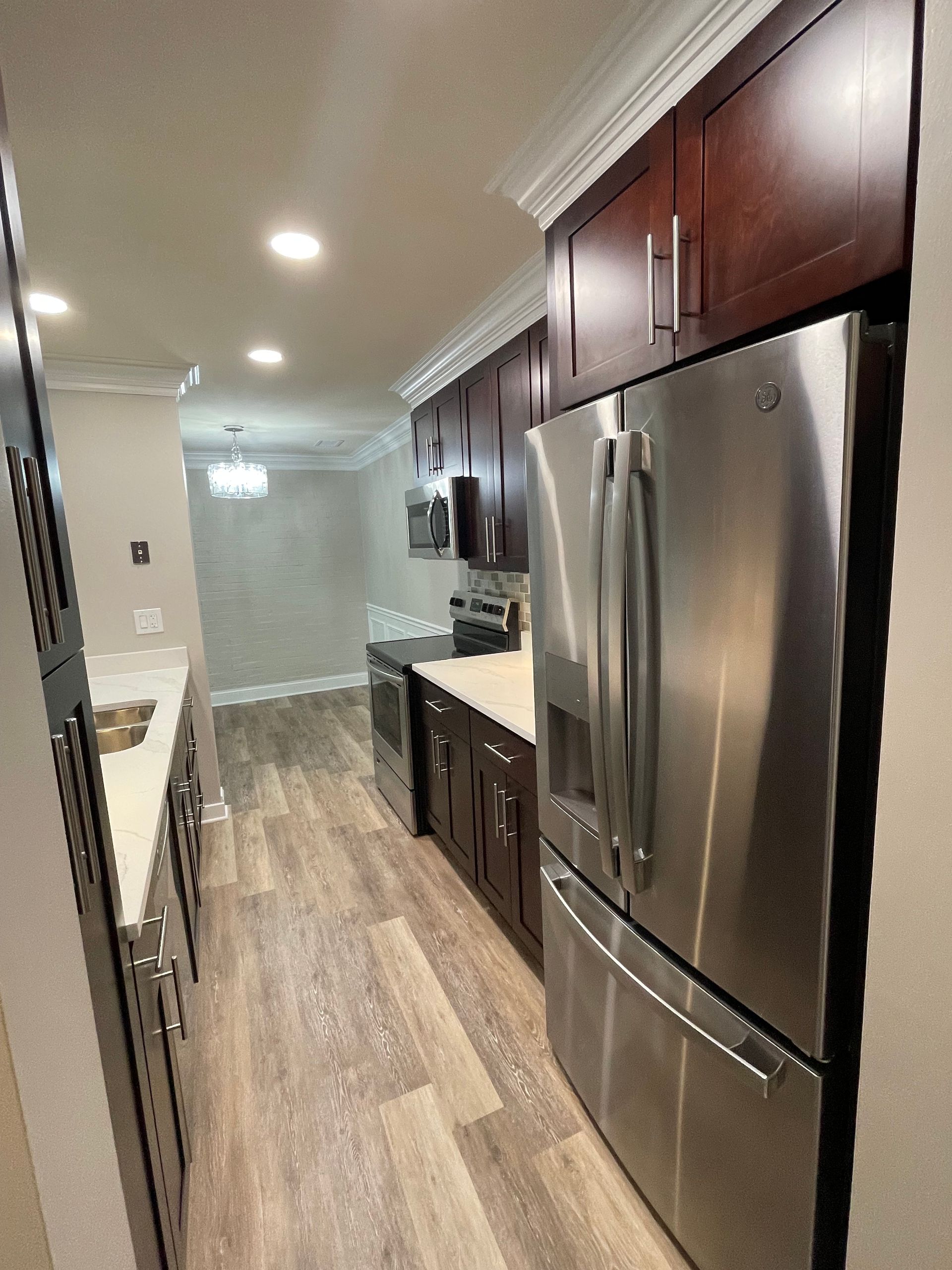 a kitchen with stainless steel appliances and wooden floors .