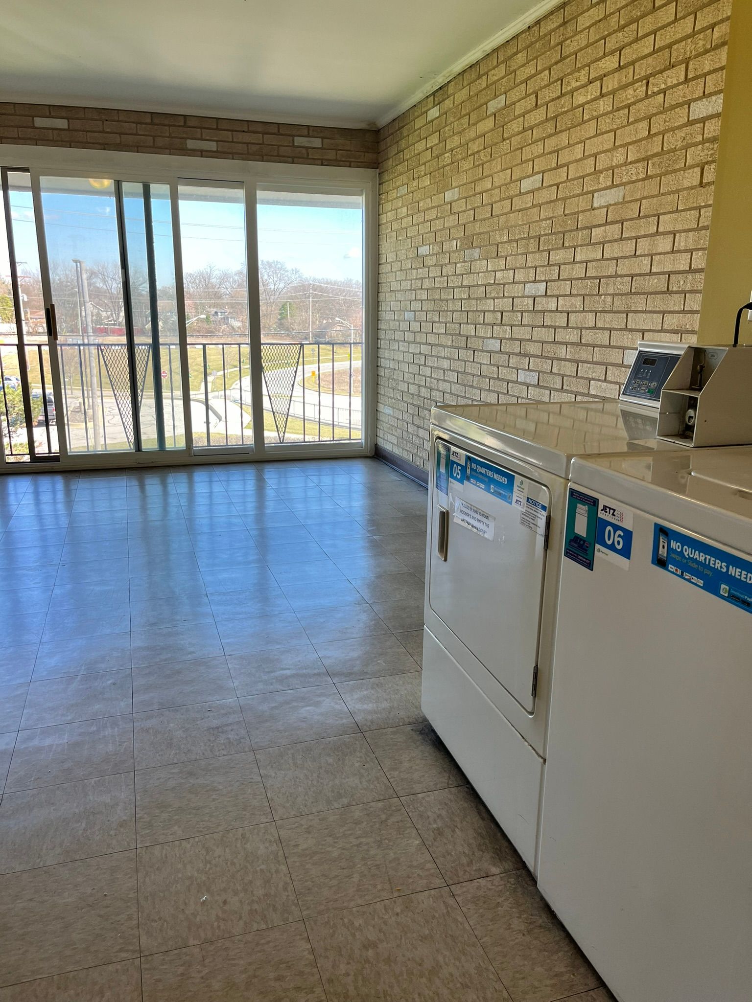 a laundromat with a brick wall and a sliding glass door .