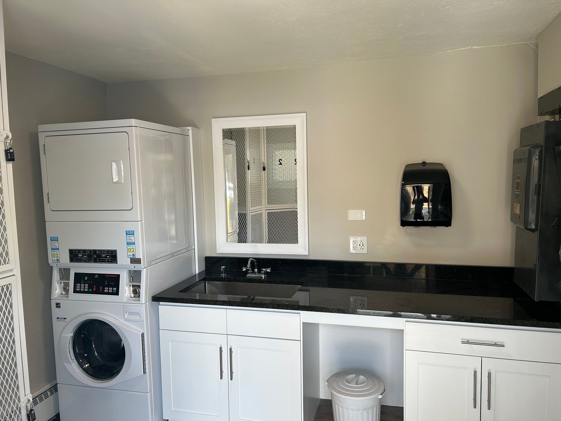 a laundry room with a washer and dryer stacked on top of each other