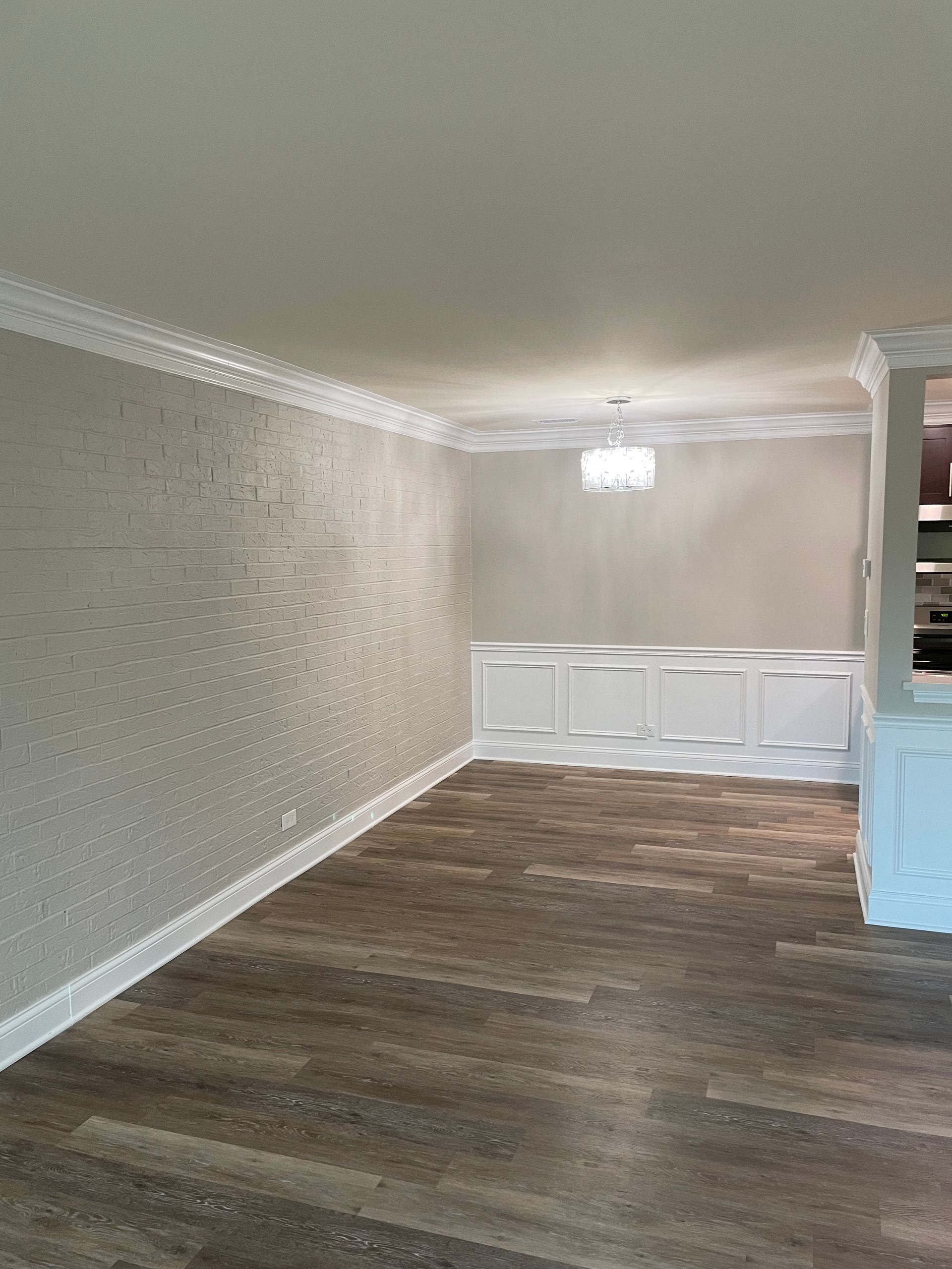 an empty living room with hardwood floors and white trim .