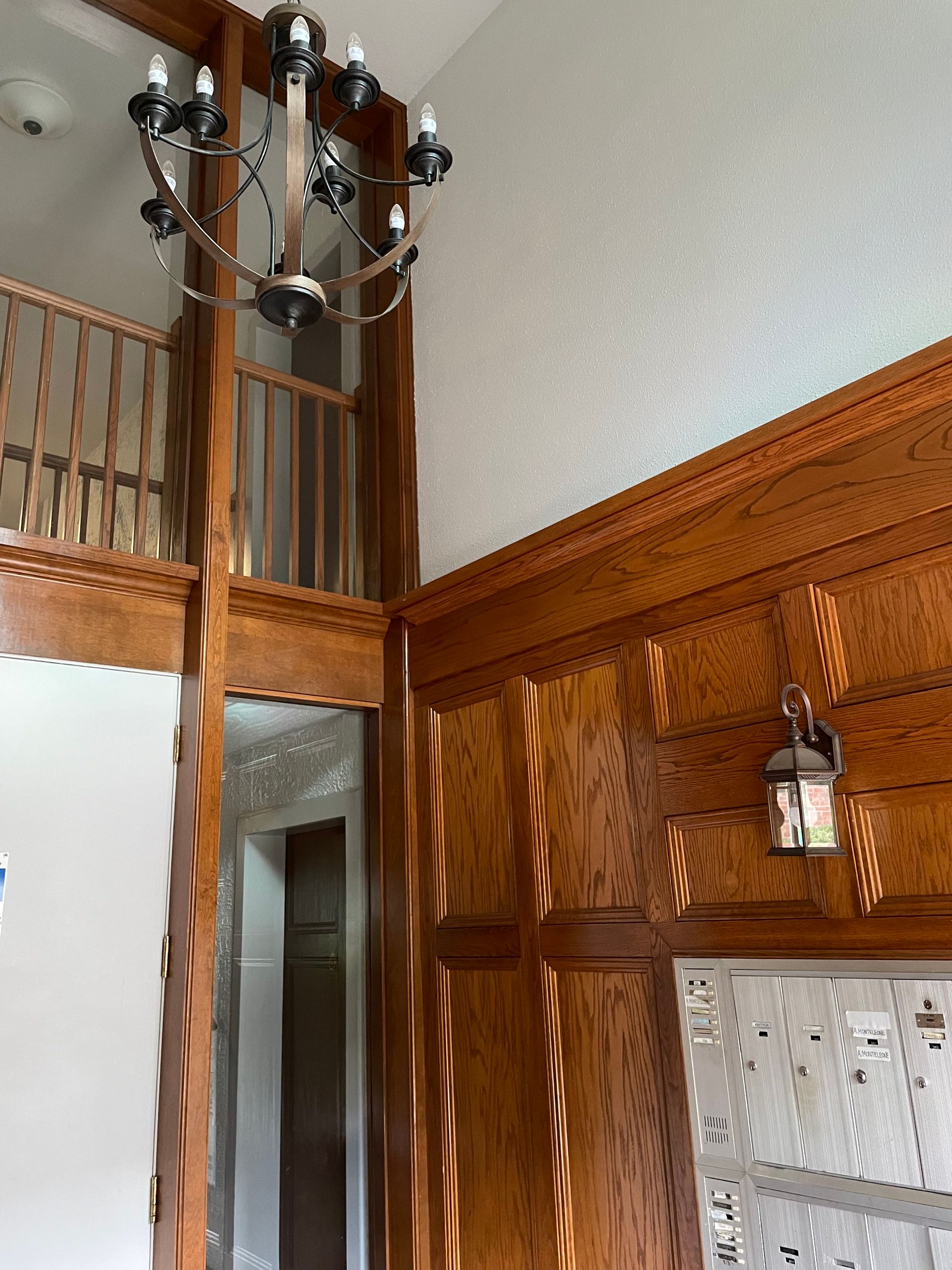 a room with wood paneling and a chandelier hanging from the ceiling .
