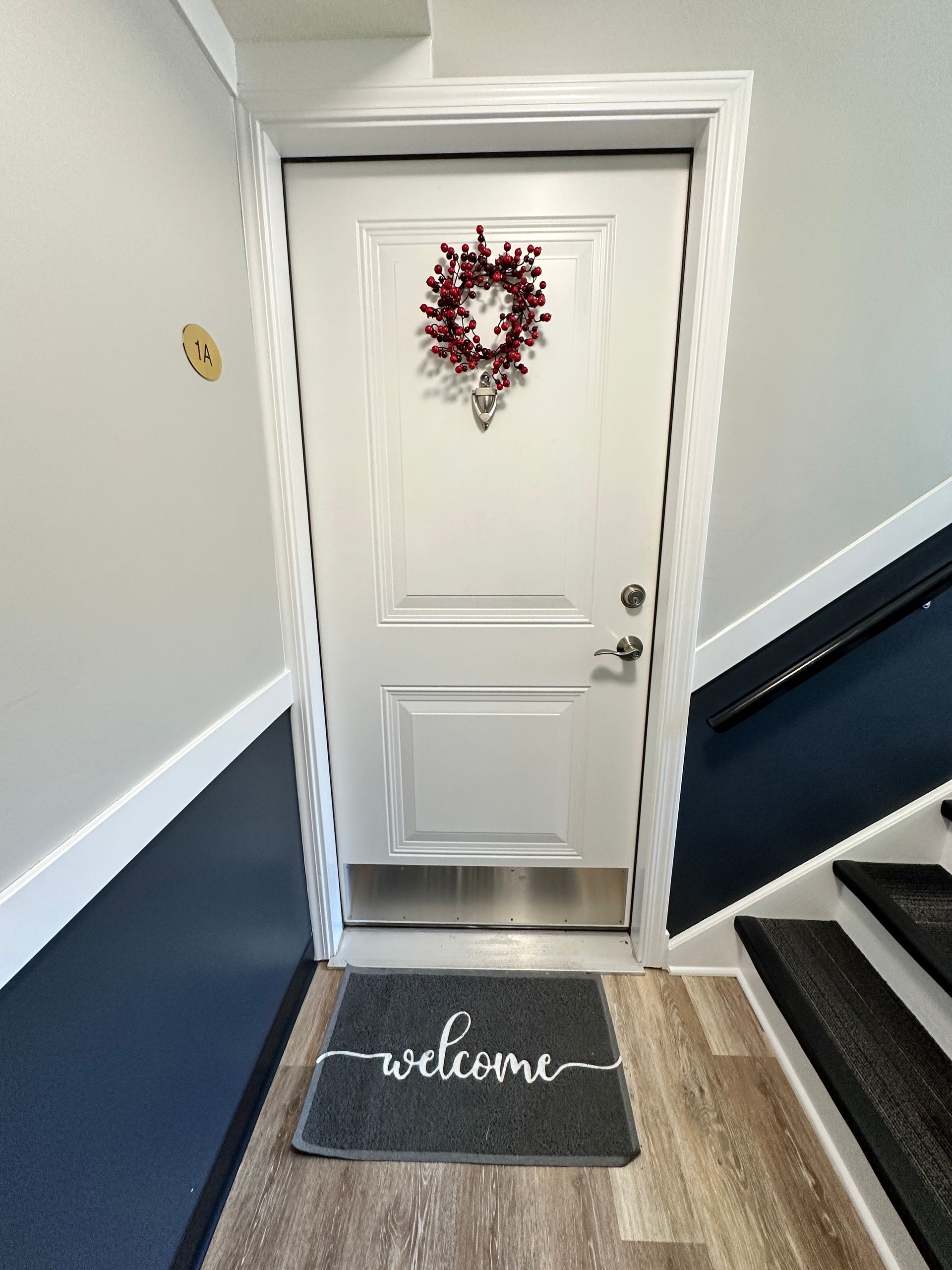 a white door with a welcome mat in front of it