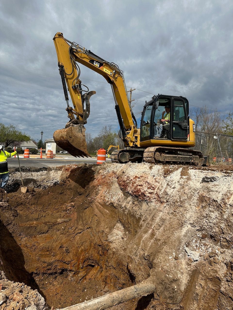 A yellow excavator is digging a hole in the ground.