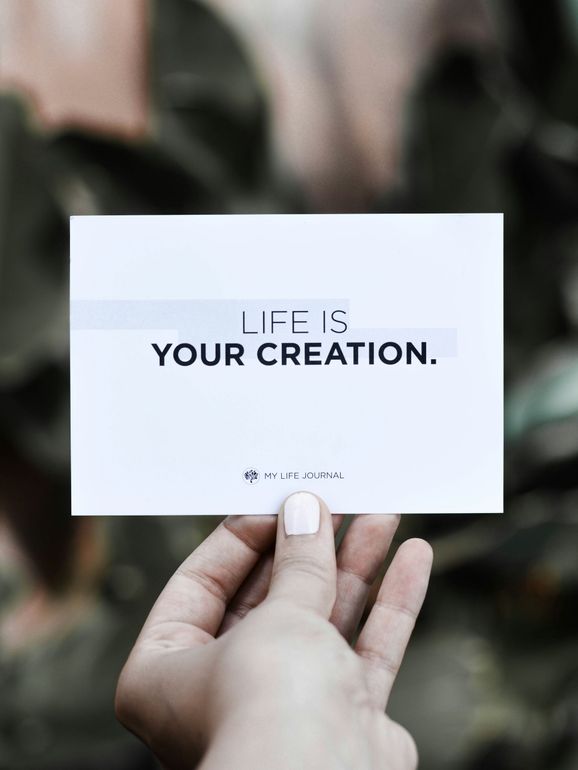 Hand holding a white card with the text 