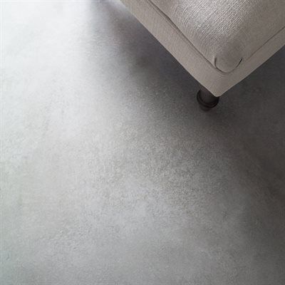Gray concrete floor with a portion of a light-colored couch.
