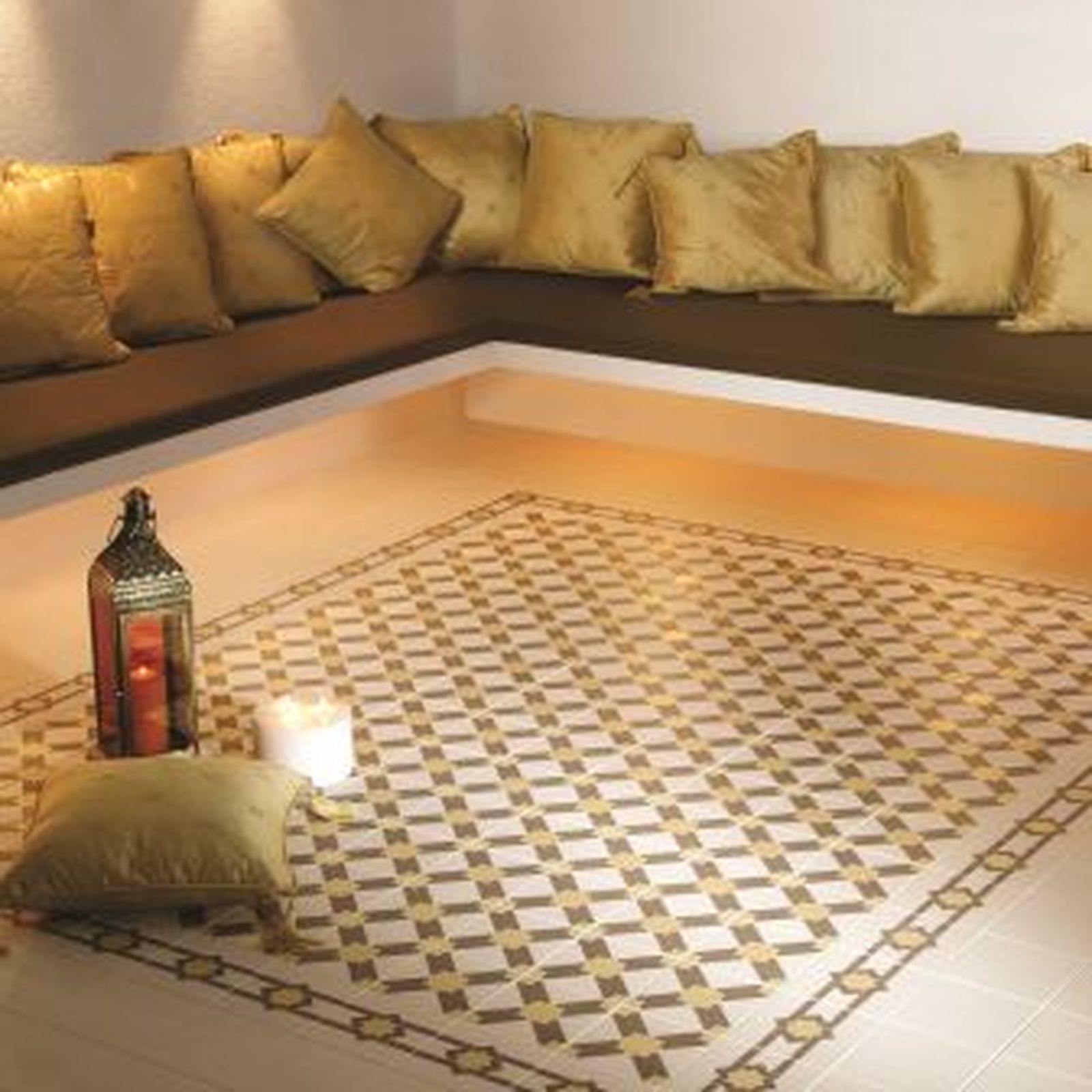 Cozy lounge area with patterned floor tiles, brown cushions, and warm lighting. A lantern and candle sit on the floor.