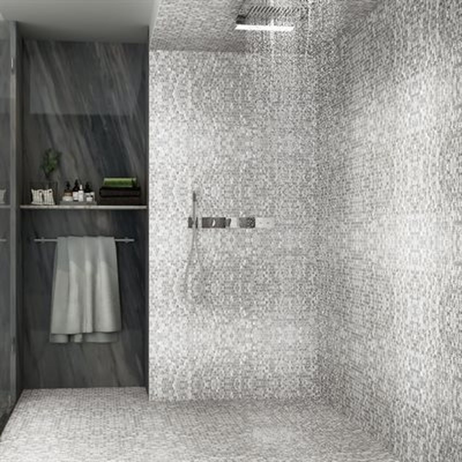 Gray tiled shower with a shelf area holding toiletries, towels.