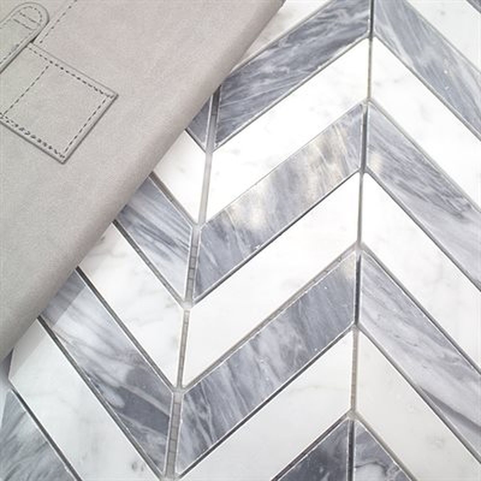 Gray leather notebook on a white and gray chevron tile background.
