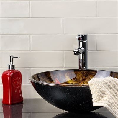 Bathroom with white tiled wall, vessel sink, chrome faucet, red soap dispenser, and towel.