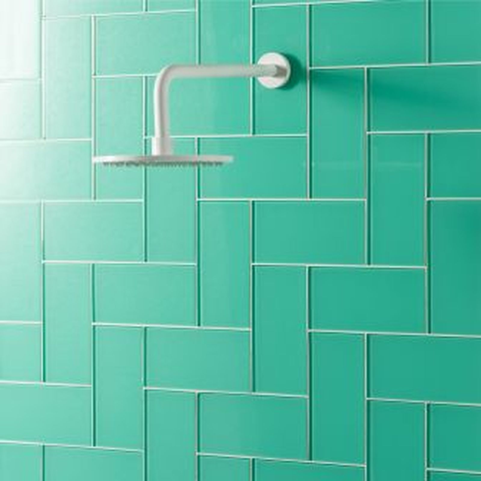 Teal-tiled shower wall with white showerhead.
