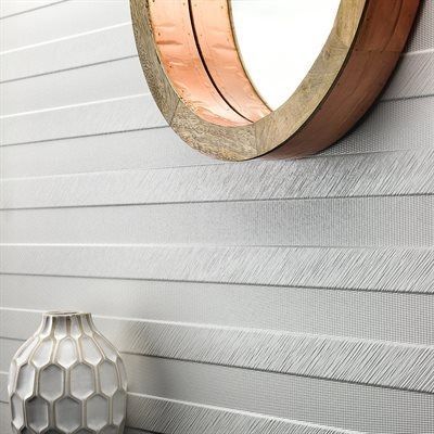 White textured wall with round mirror and vase.