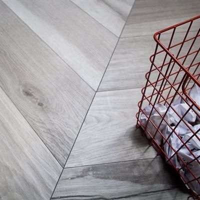Herringbone wood floor with red wire basket filled with white wrapped items.