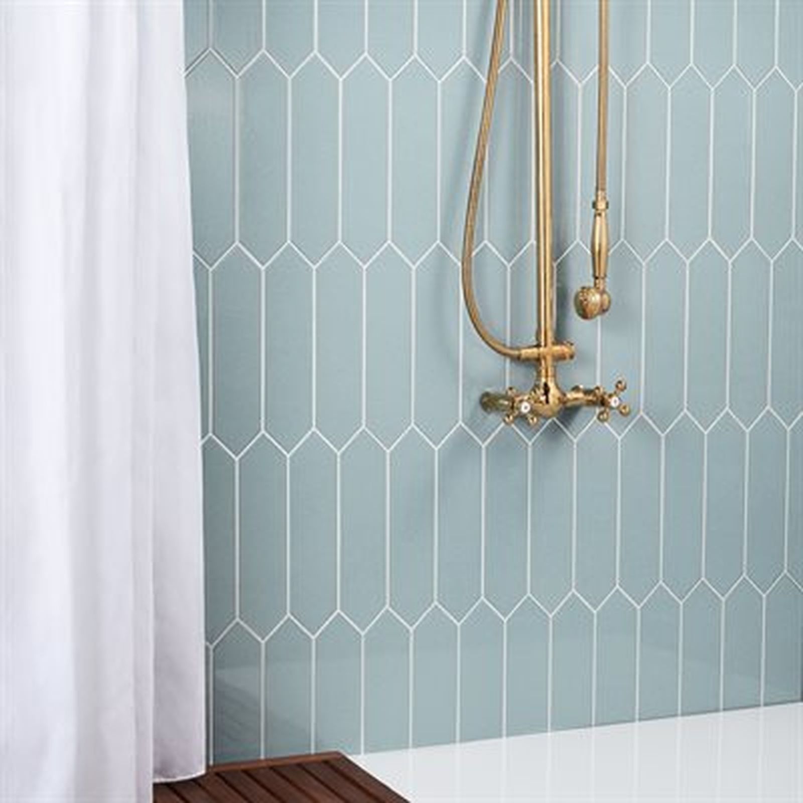Shower with blue tile wall and gold fixtures. White shower curtain hangs on the left.